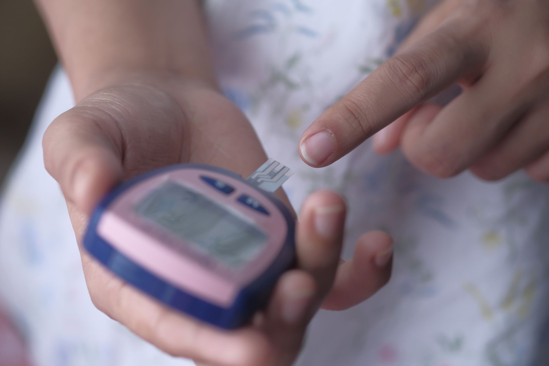 Person checking blood glucose levels with a meter, showcasing pre-operative monitoring.