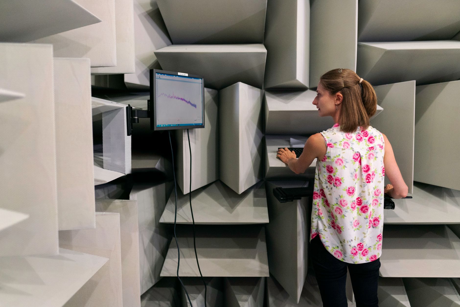 Audiologist conducts a hearing test in a soundproof lab, analyzing data.