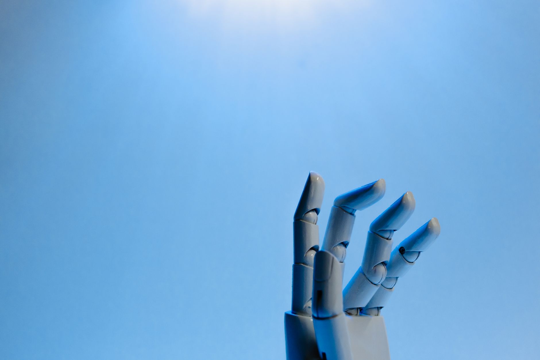 A robotic hand displayed against a blue background, showcasing advanced precision technology.