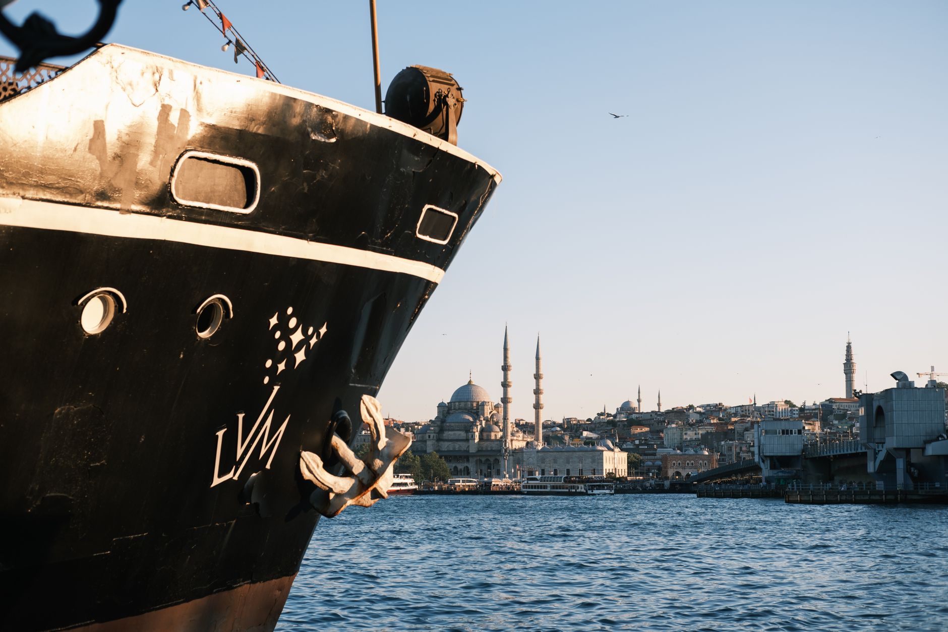 A ship's bow in the foreground, Istanbul's skyline with mosques visible in the background.