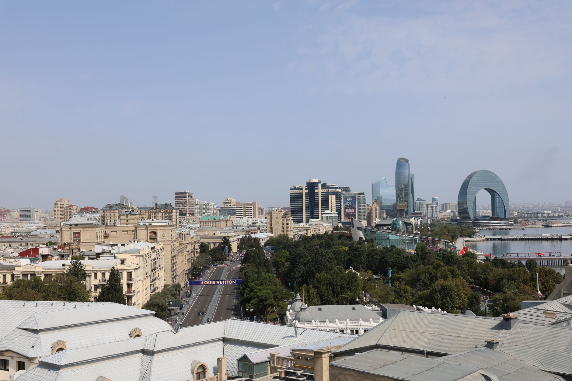 Aerial view of Baku showcasing modern skyscrapers and historic buildings by the waterfront.