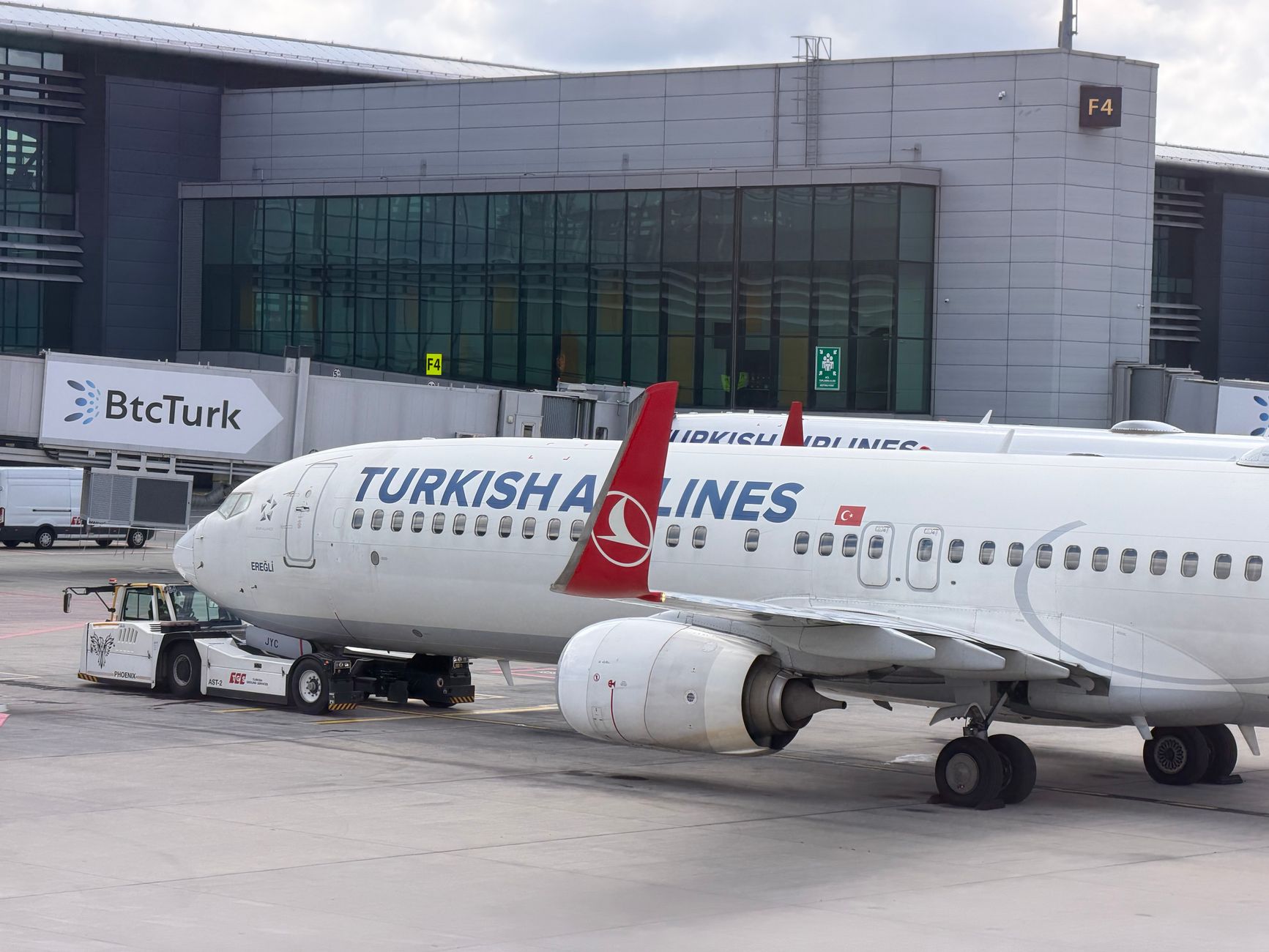 A Turkish Airlines plane parked at Istanbul Airport, with terminal F4 in the background.