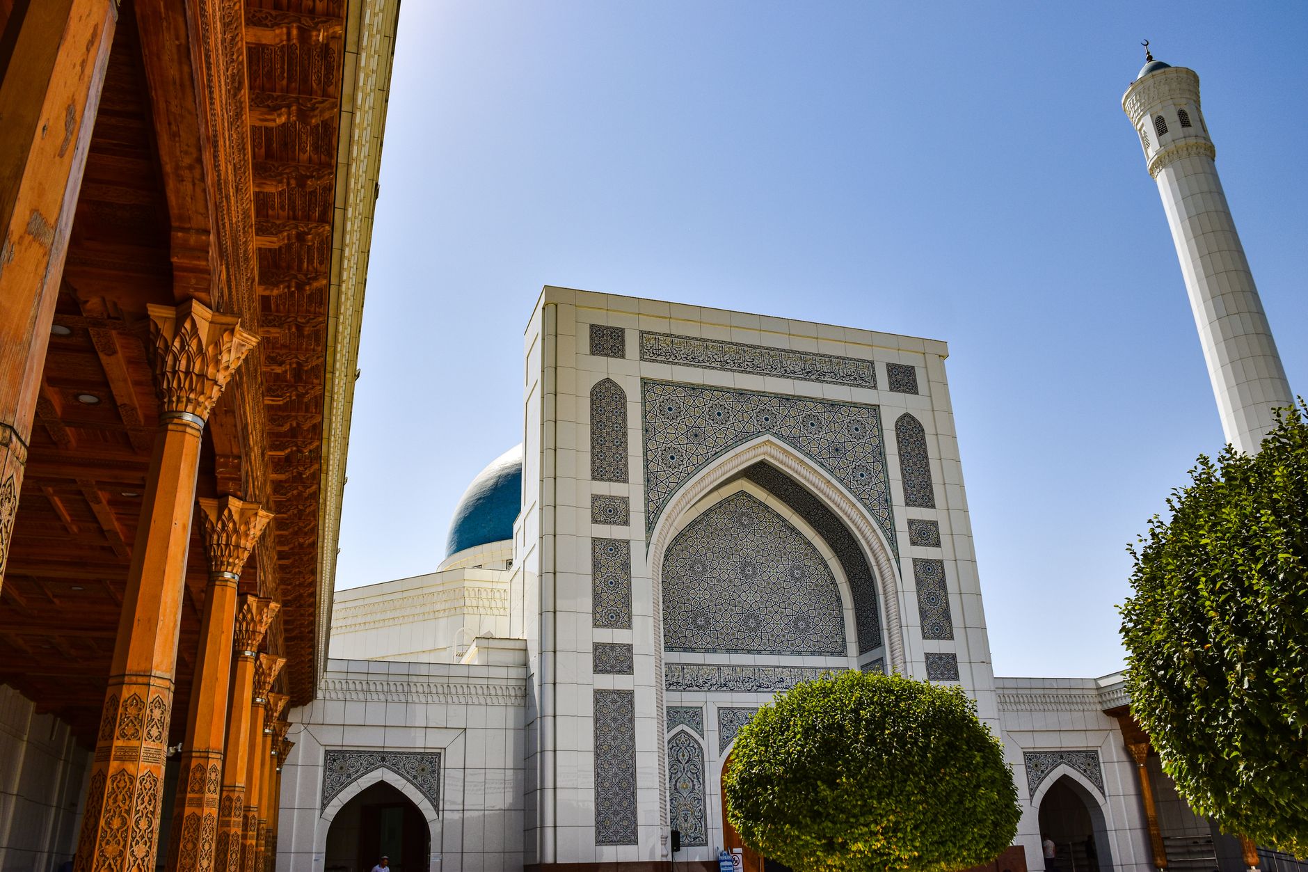 View of intricate architecture in Tashkent, Uzbekistan with a blue dome and decorative columns.