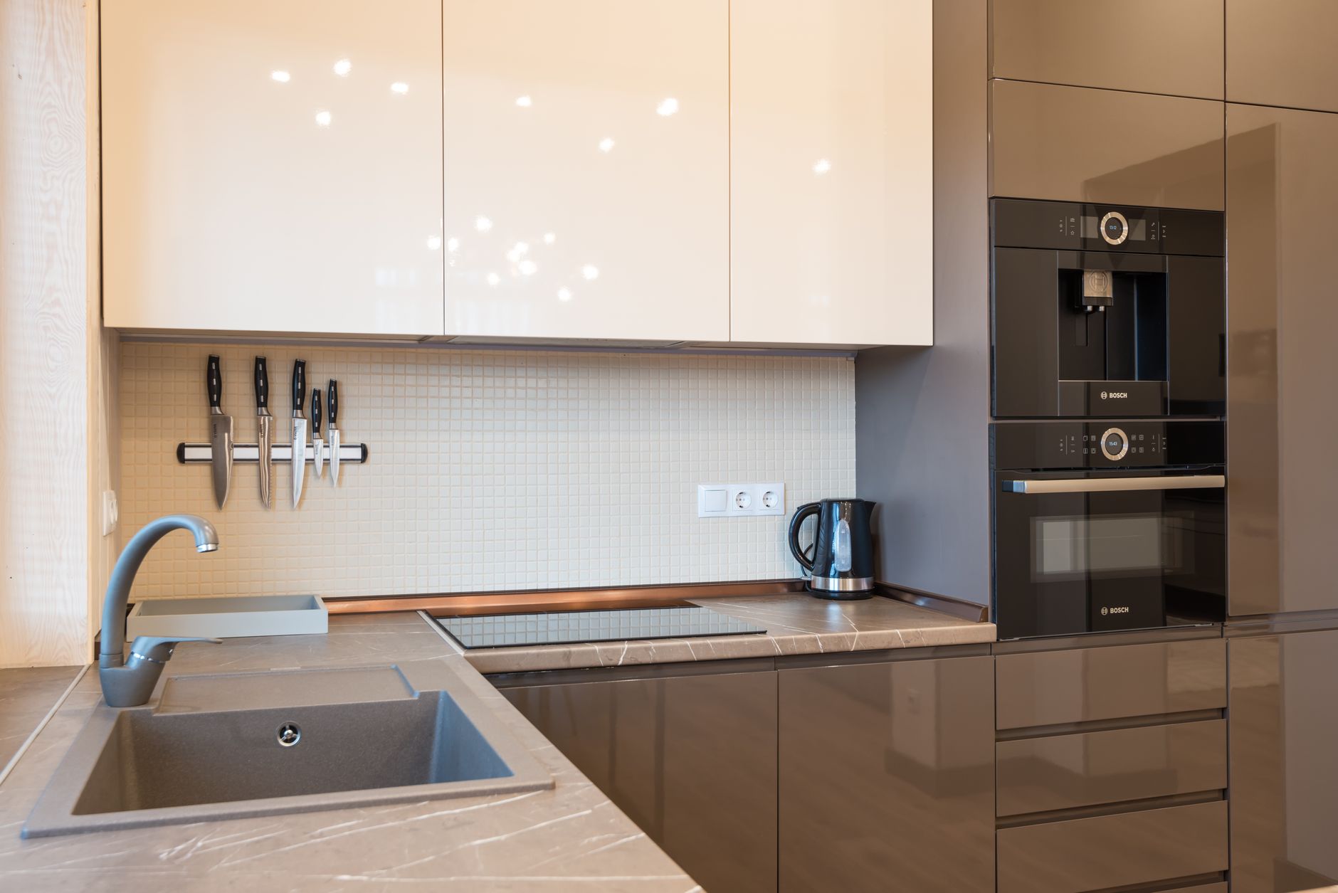 Stylish kitchenette featuring a sink, oven, and knives, designed for meal prep in a recovery residence.