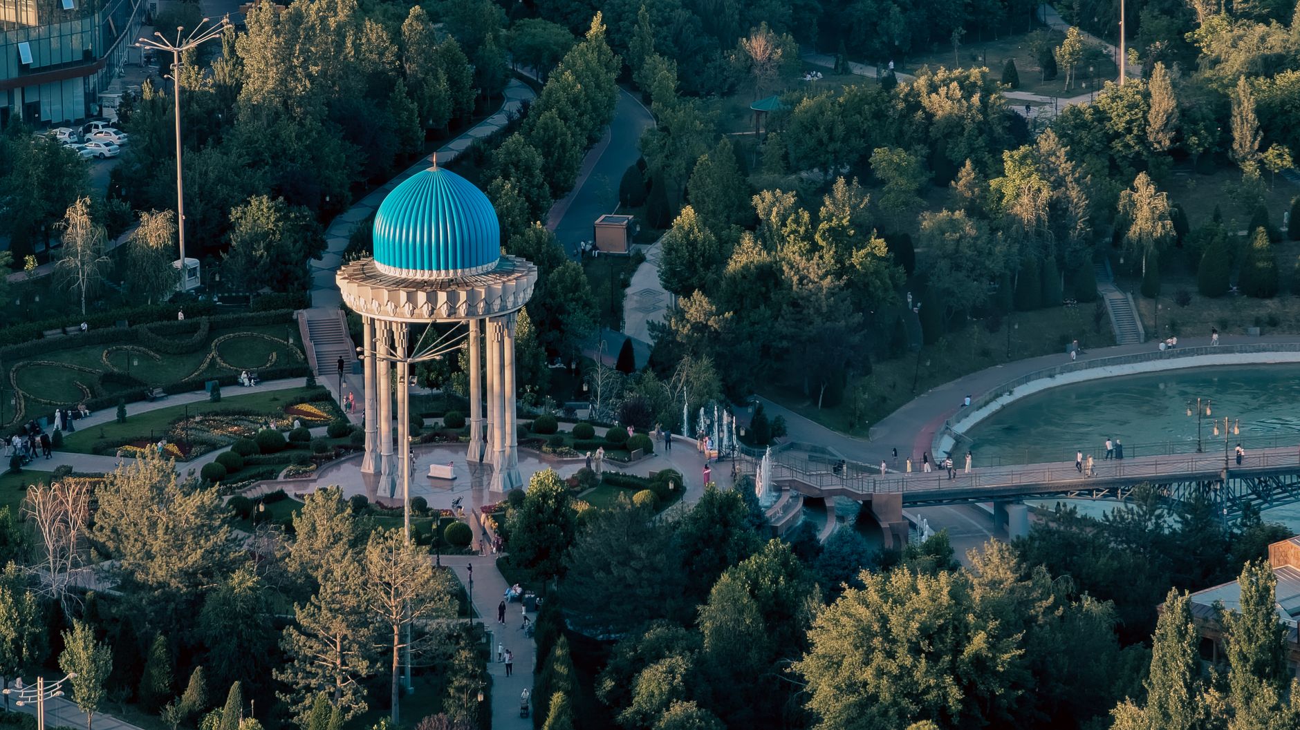 Aerial view of Tashkent park featuring a turquoise dome monument surrounded by greenery.