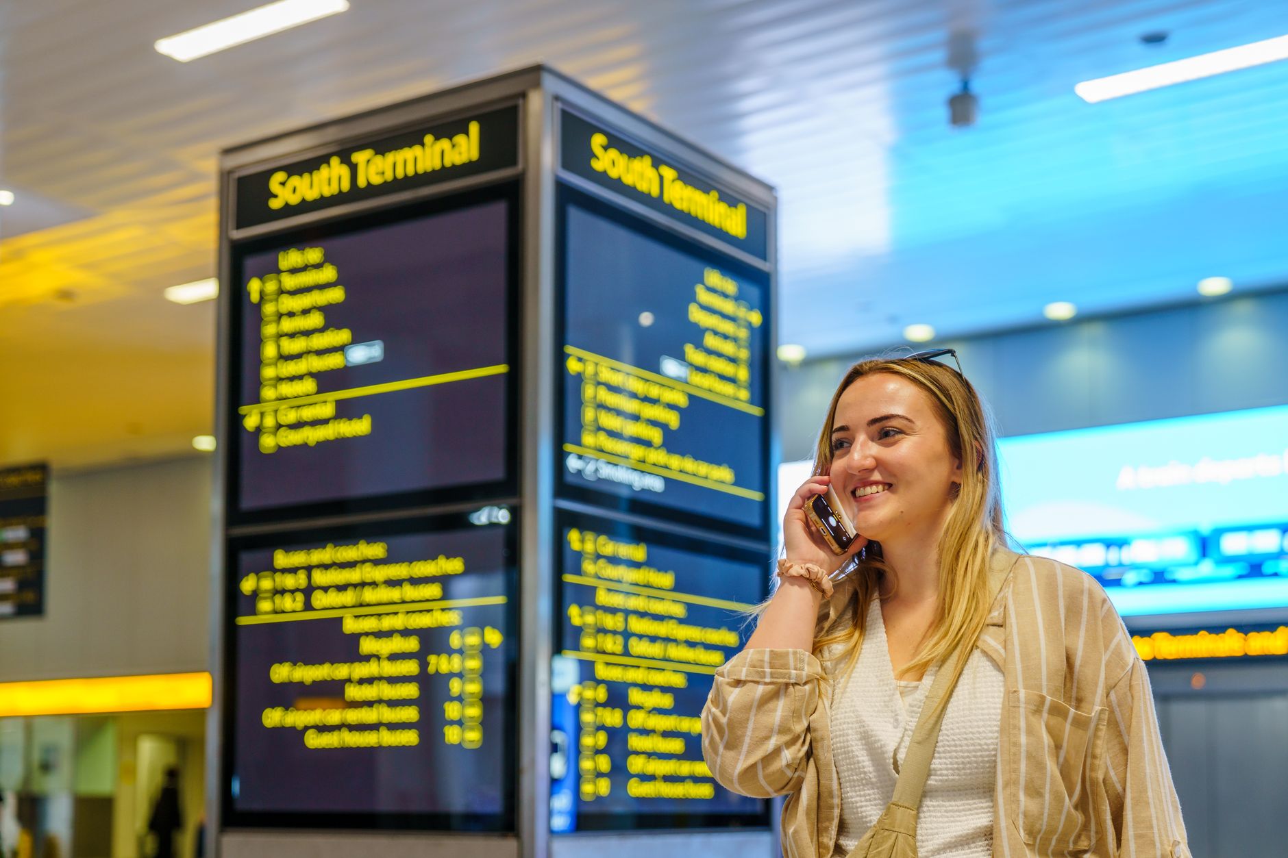 A coordinator at Istanbul Airport South Terminal smiles while on the phone.