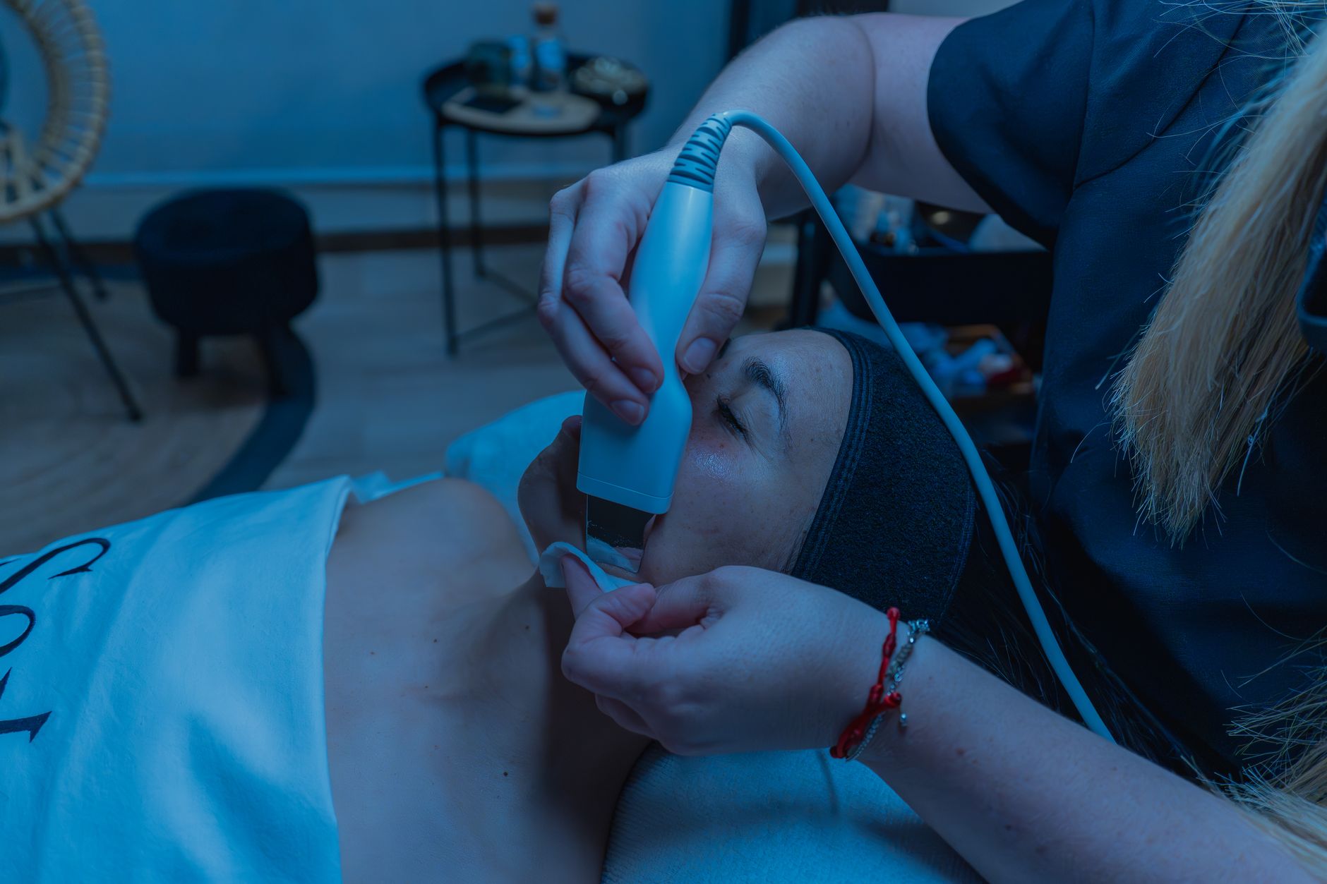 A skin treatment session showing a HIFU device being used on a client's face.