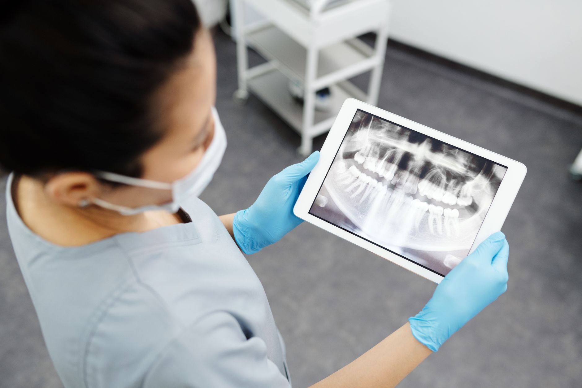 Orthodontist examining a dental X-ray on a tablet device.