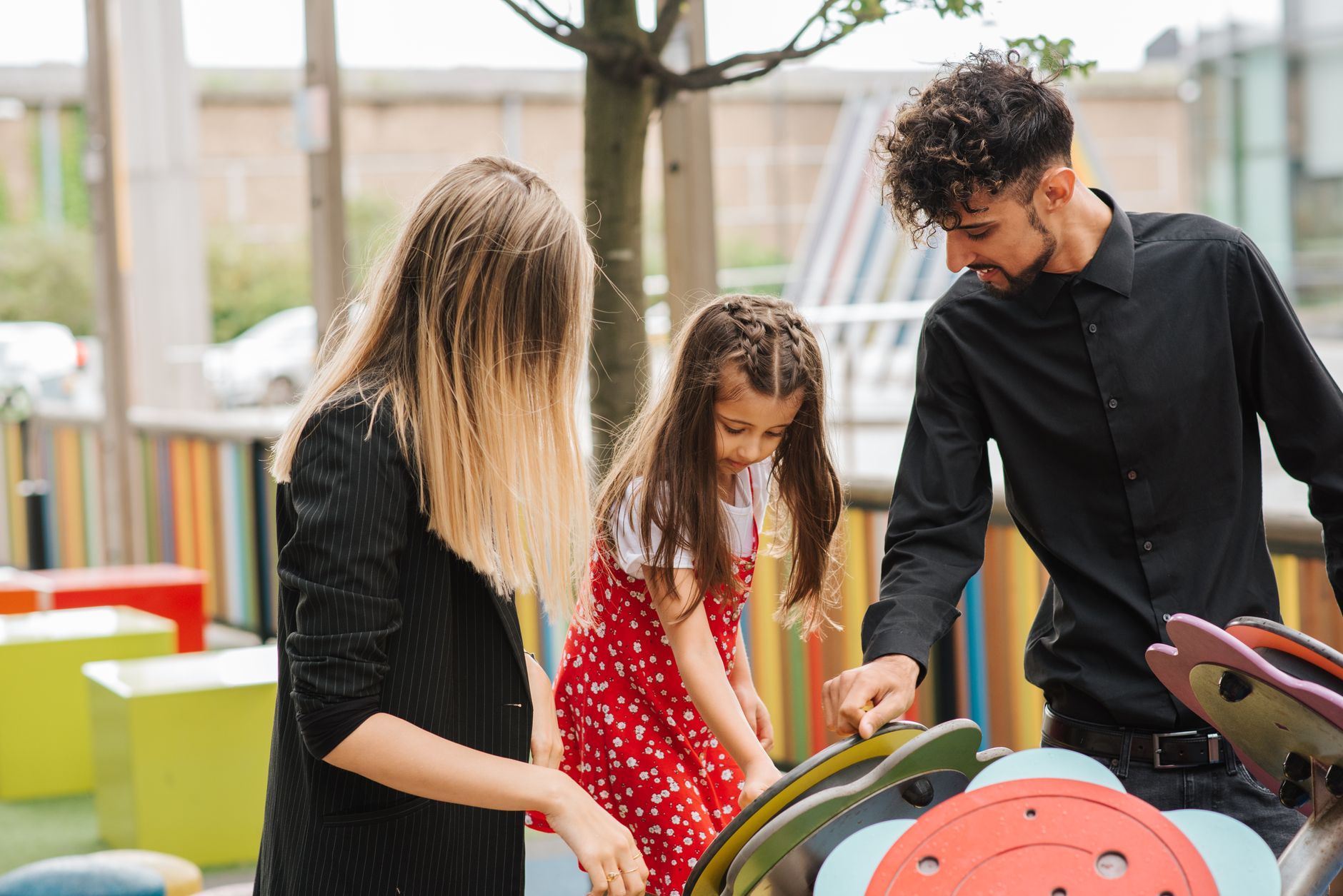 A family engages in play at a colorful hospital play area, promoting family-centered care.