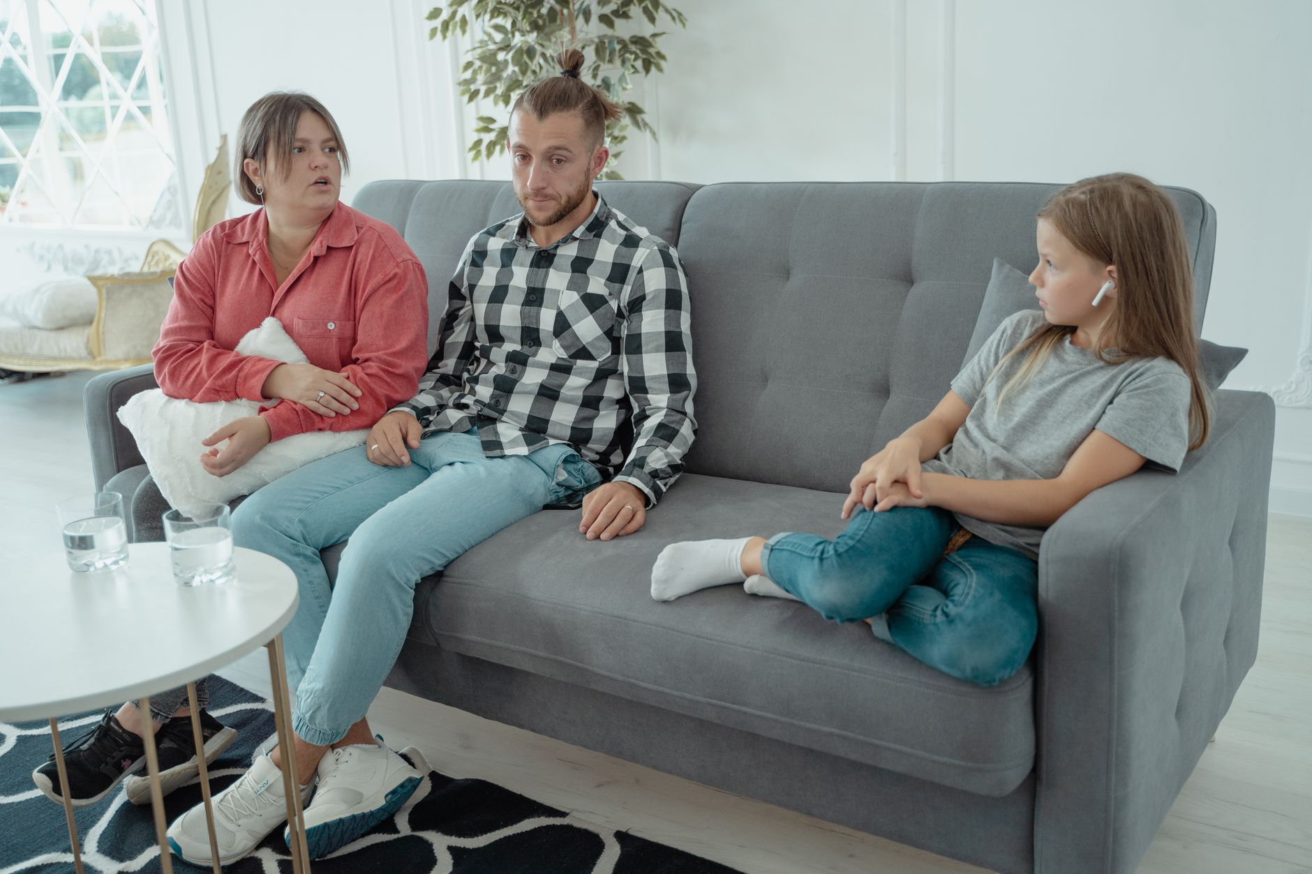 Parents discussing with a counselor while their child plays nearby, showcasing family-centered support.