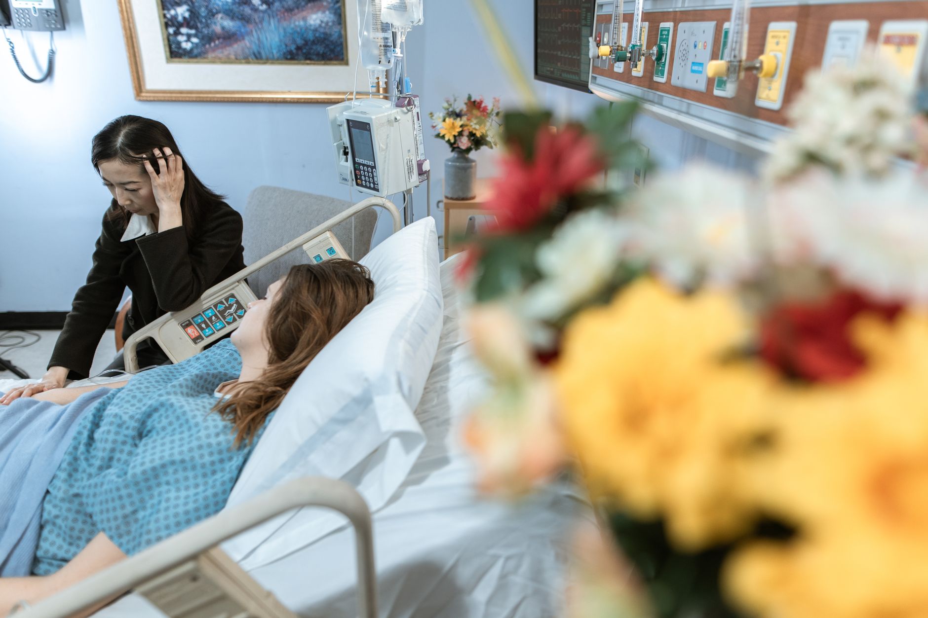 A woman comforting a hospital patient in a Turkish hospital room.