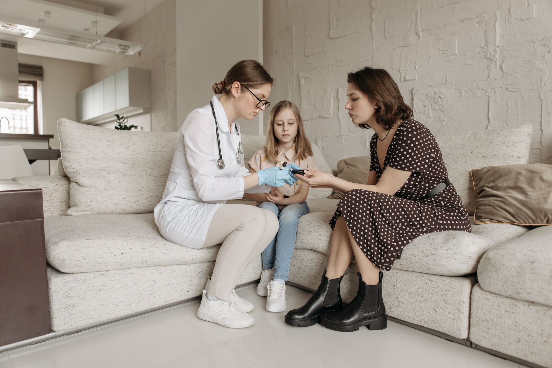 A doctor discusses a care plan with a mother and child in a cozy consultation room.