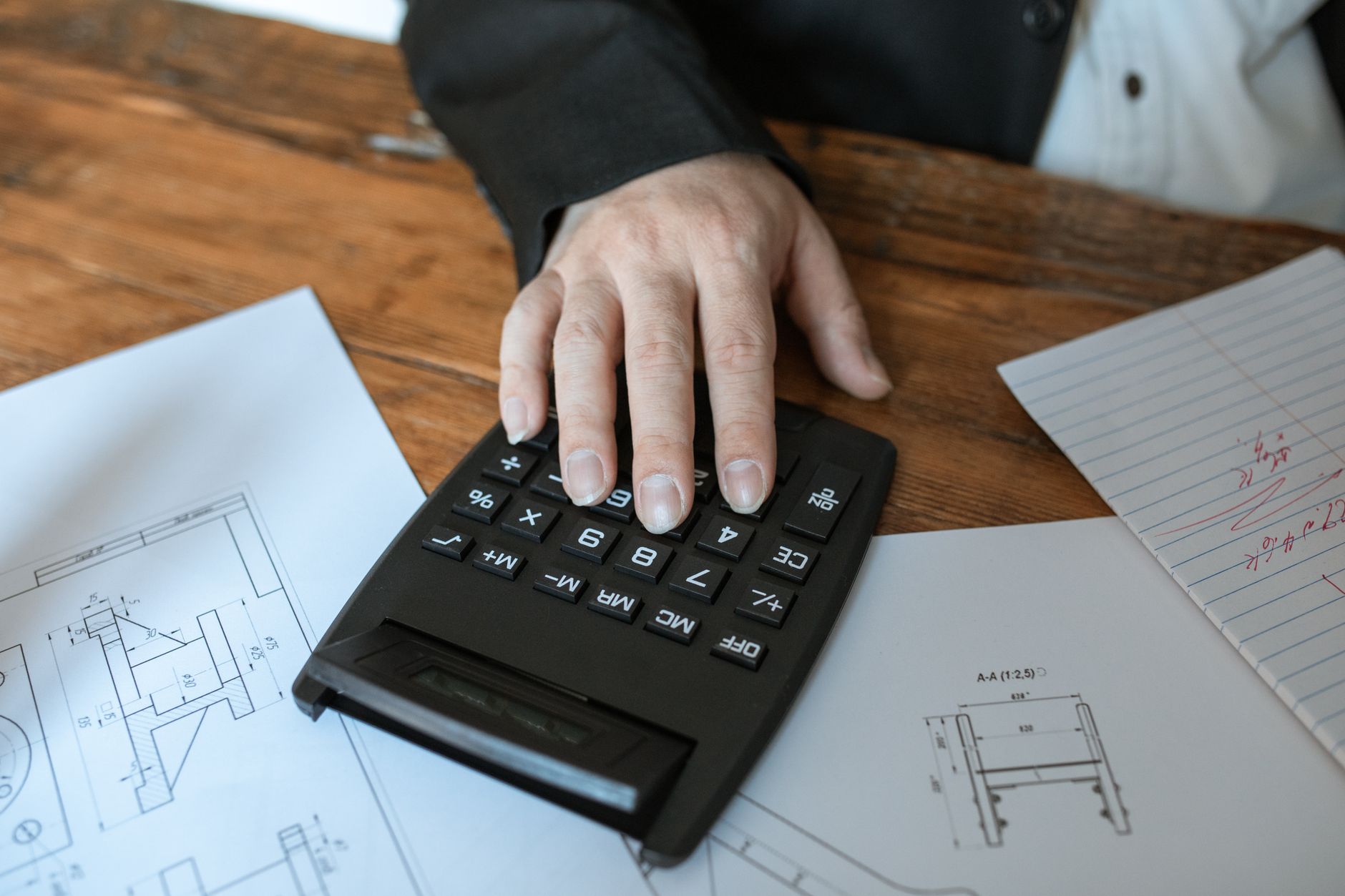 A financial advisor using a calculator to discuss instalment plans with a couple.