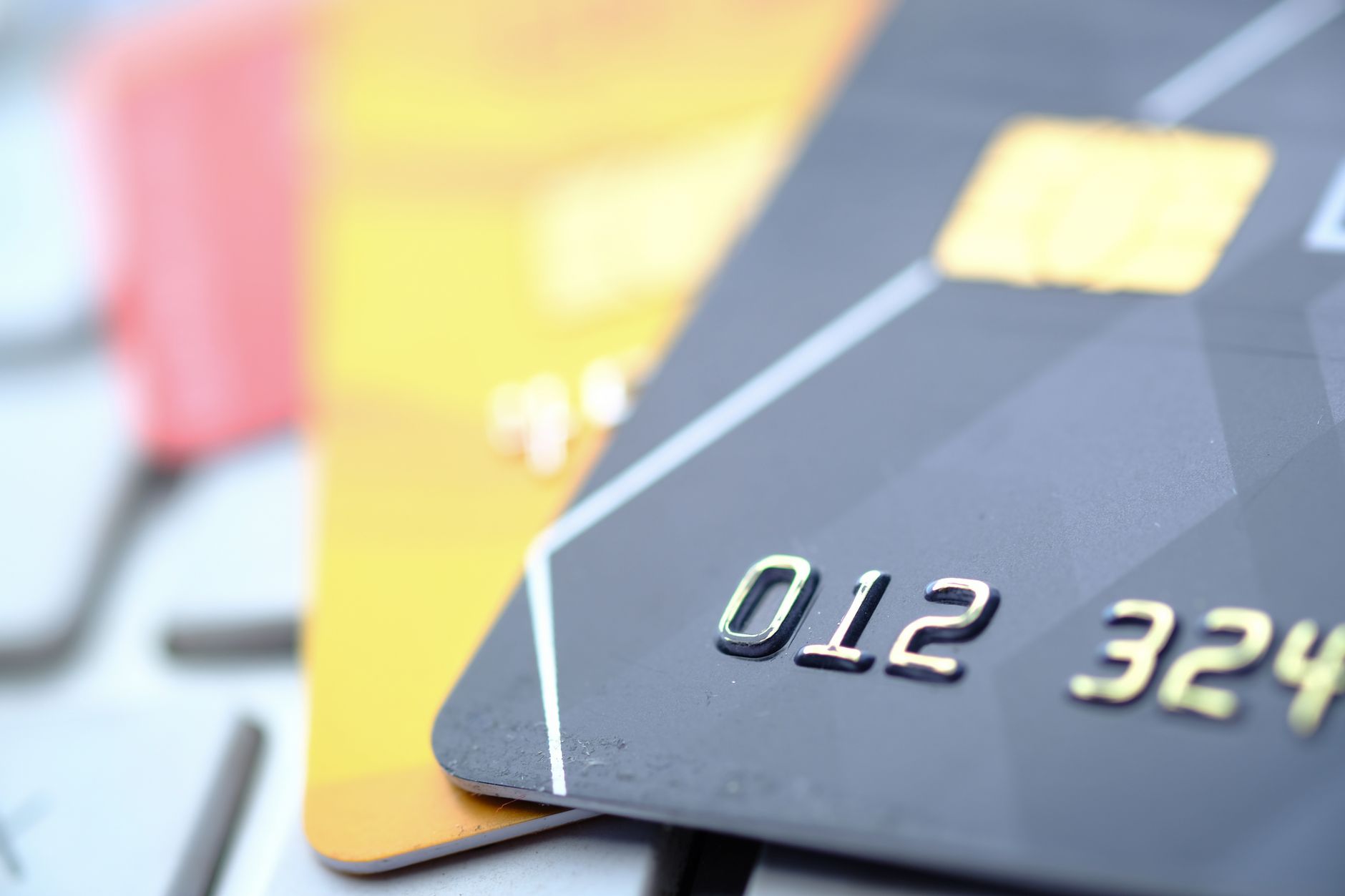 Close-up of black and yellow bank cards on a keyboard, representing secure online payments for medical treatment.