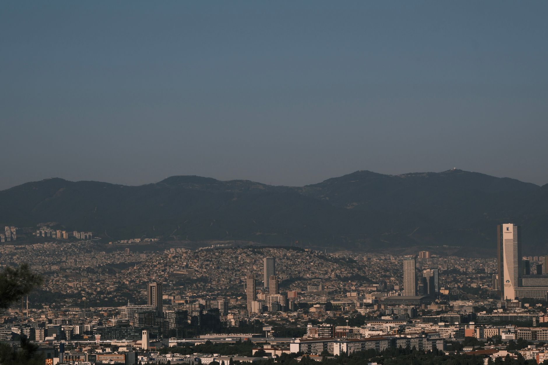 A panoramic view of Izmir's skyline against mountains in the background.