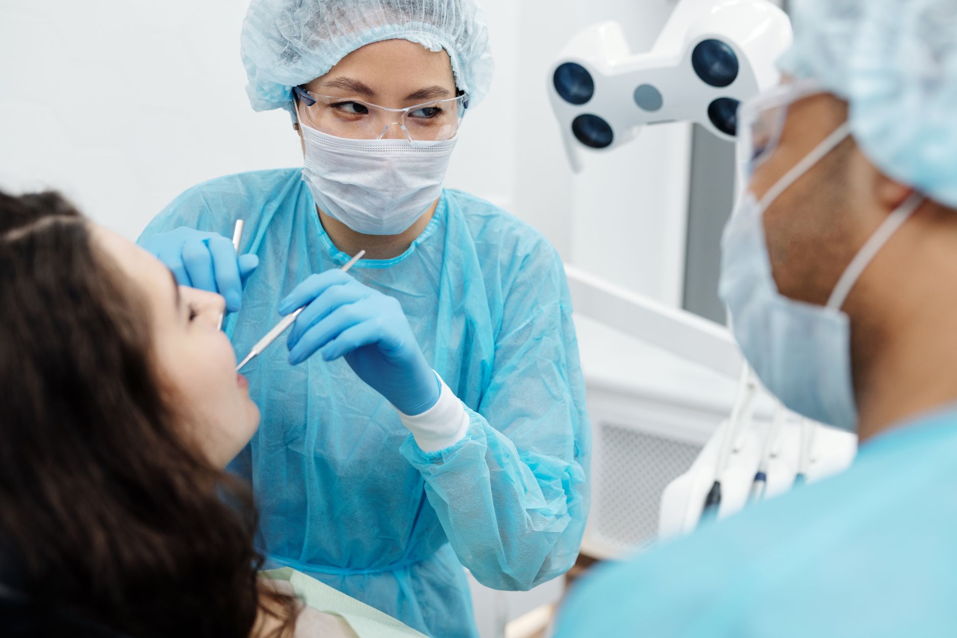 Dentist performing a TMJ examination on a patient in a bright clinic.