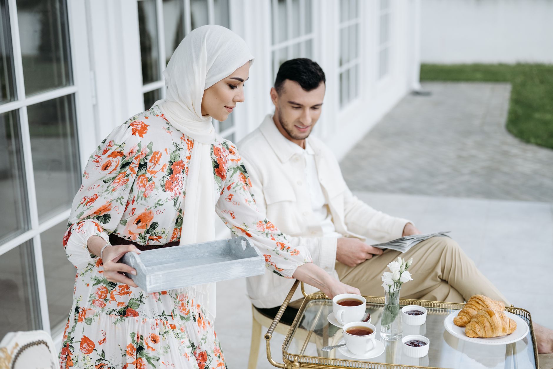 A couple relaxing with Turkish tea and pastries in a serene garden setting.