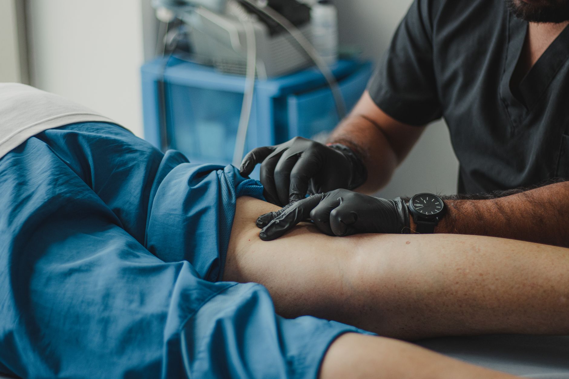 Healthcare professional providing post-operative care on a patient's arm.