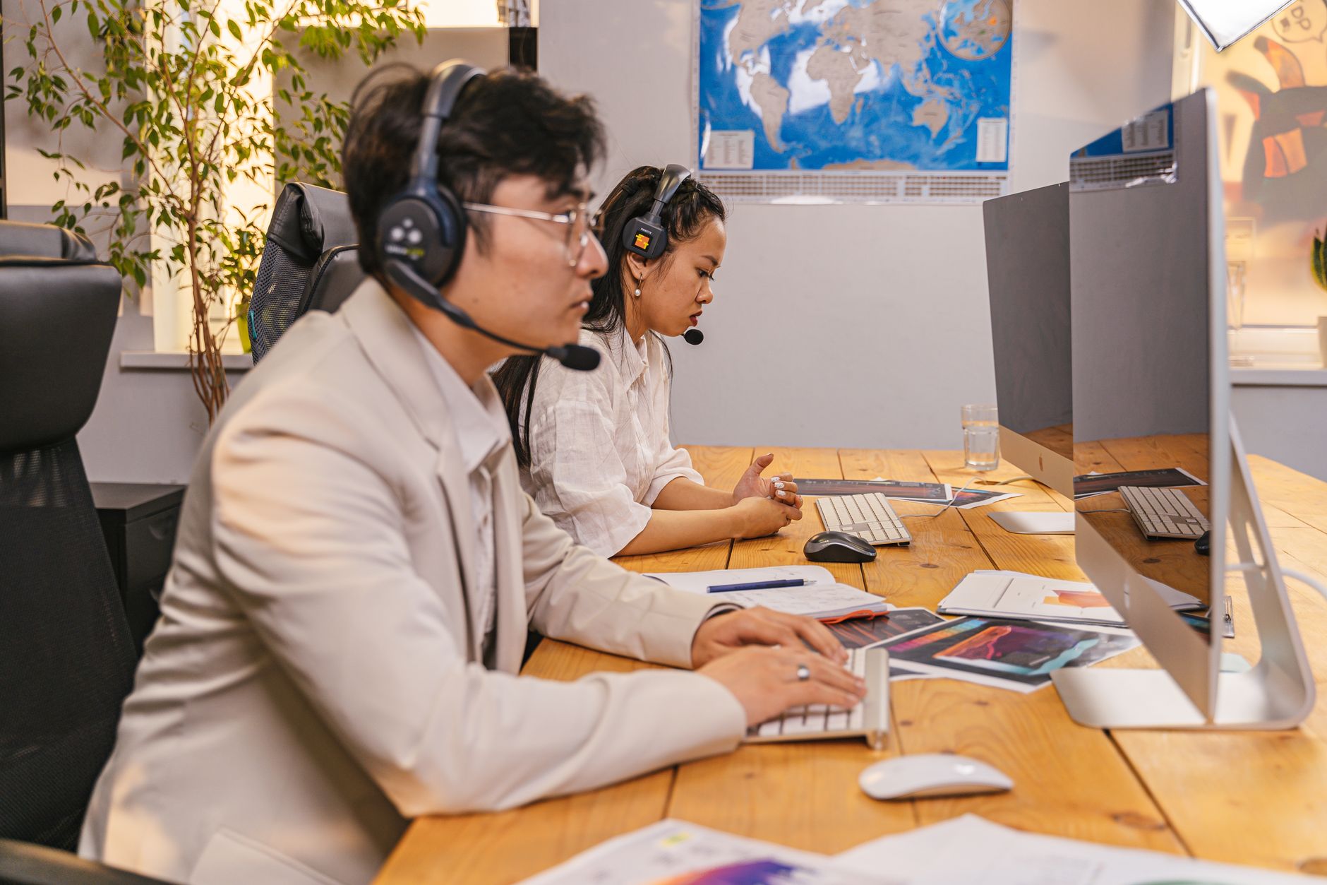 Two coordinators with headsets working at computers providing 24/7 patient support.
