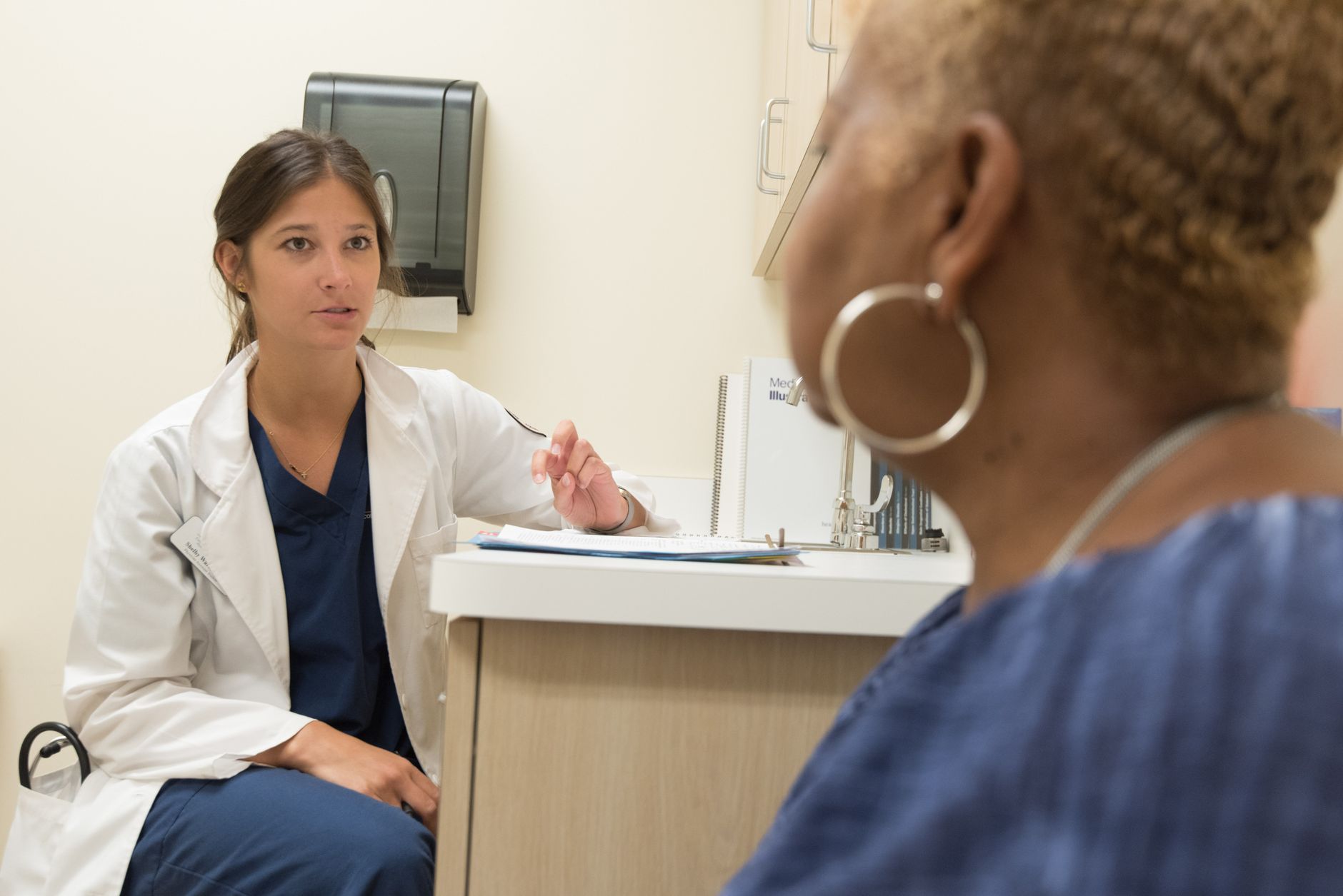 A medical professional discussing aftercare instructions with a patient in a healthcare setting.