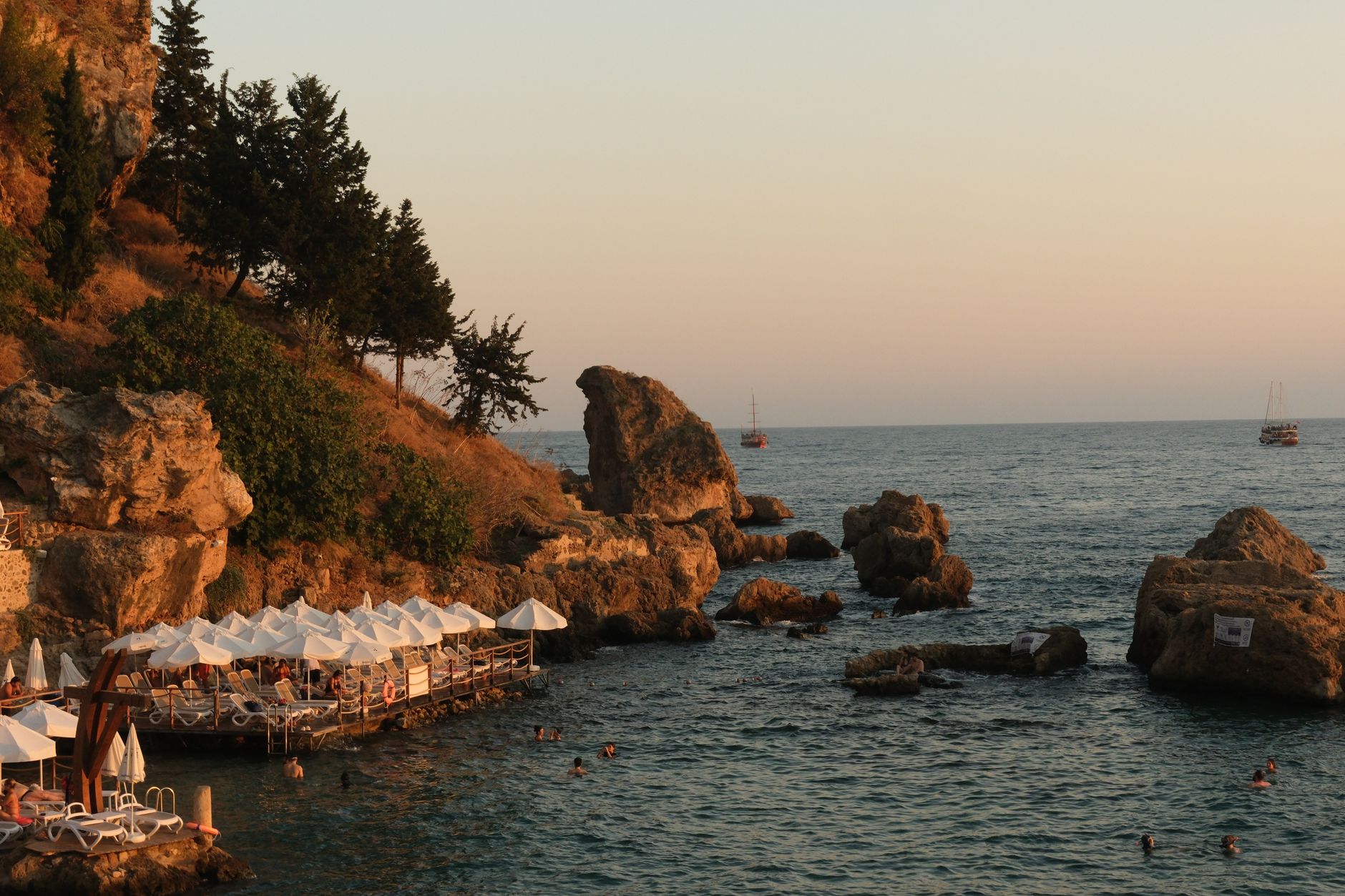 Tranquil Antalya resort garden overlooking the sea with sun loungers.