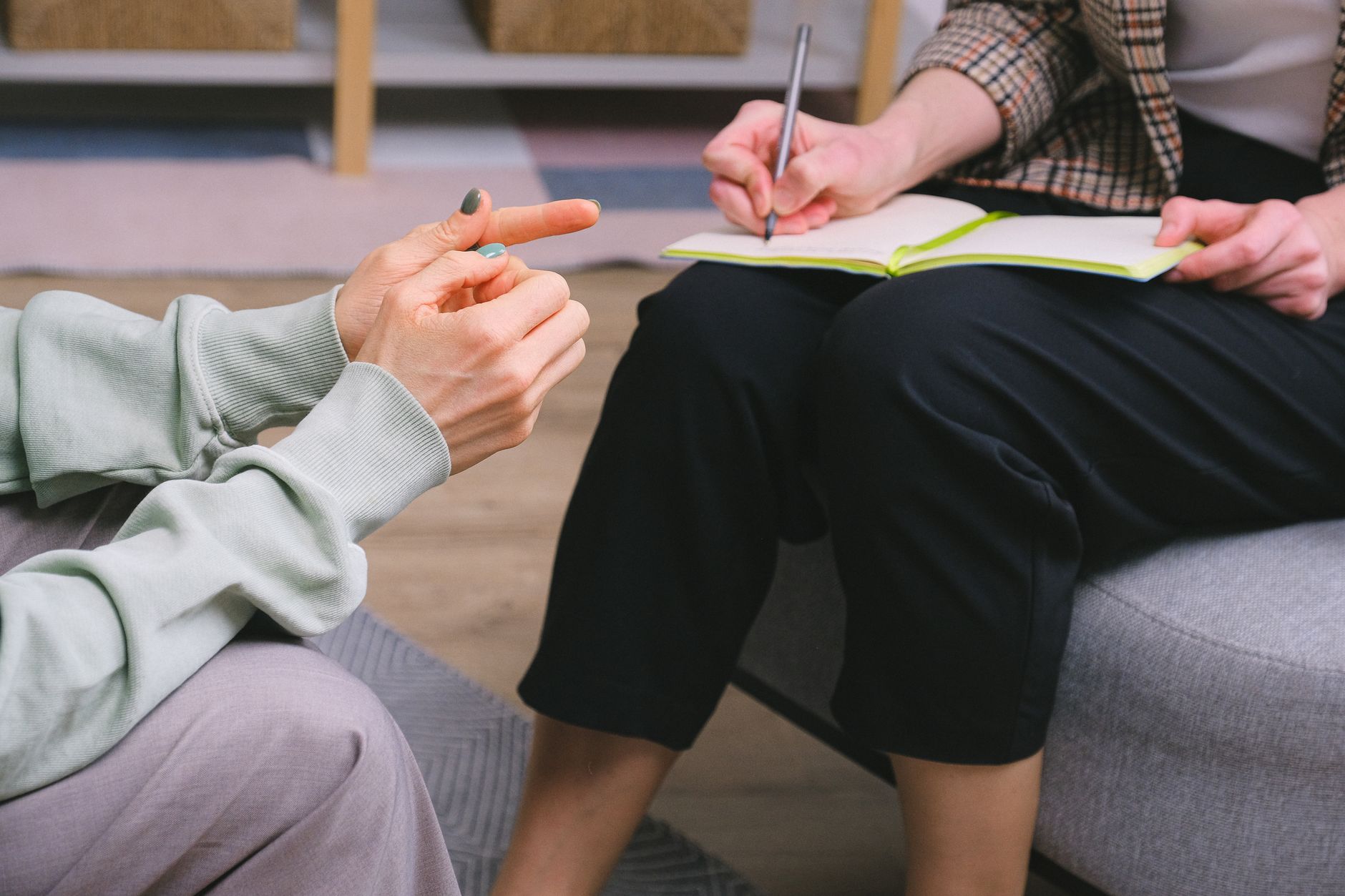 A speech-language pathologist discusses with a stroke survivor, writing notes.