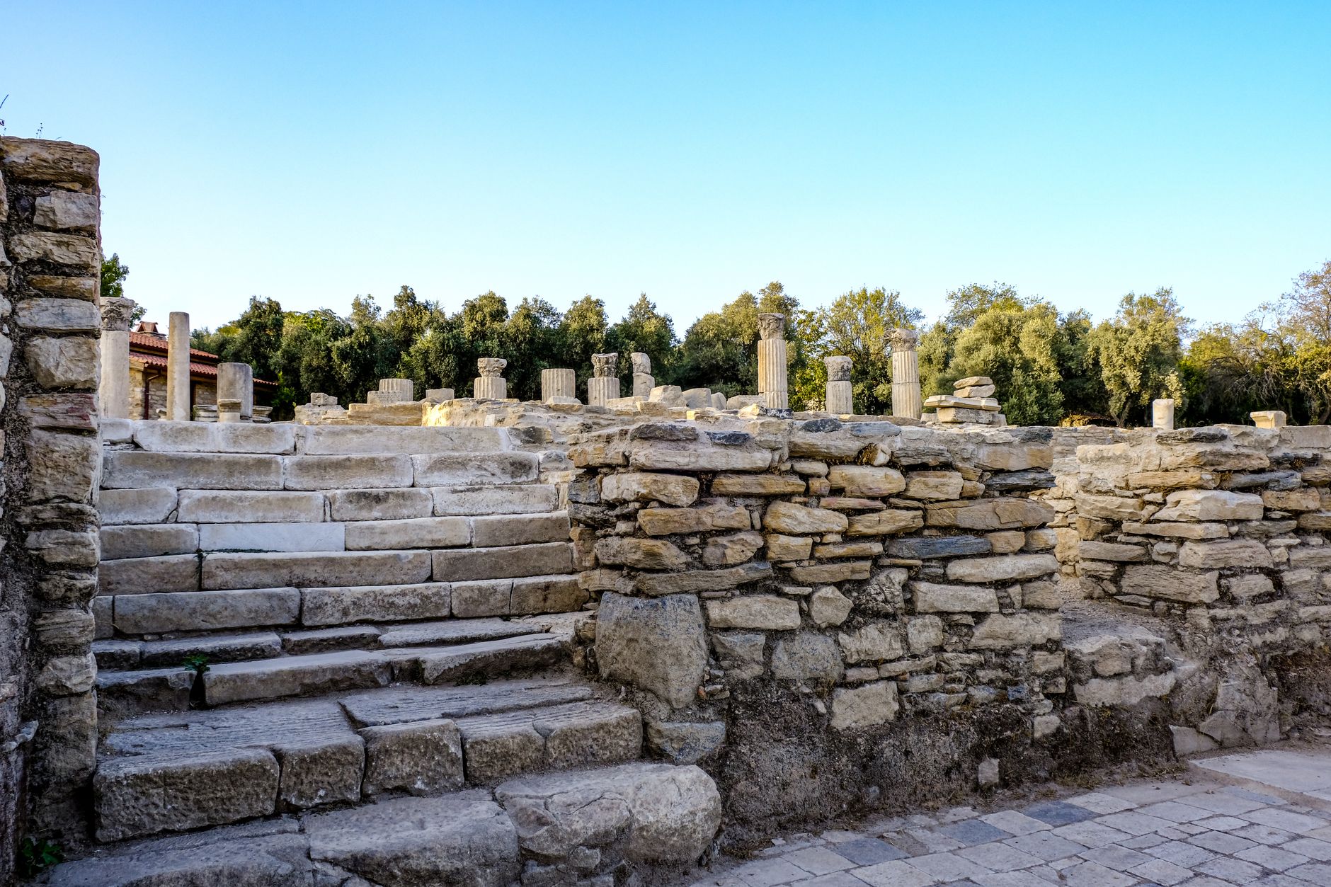 Stratonikeia'da antik sütunlar ve yeşilliklerle çevrili restore edilmiş Kuzey Hamamı'na çıkan basamaklar.