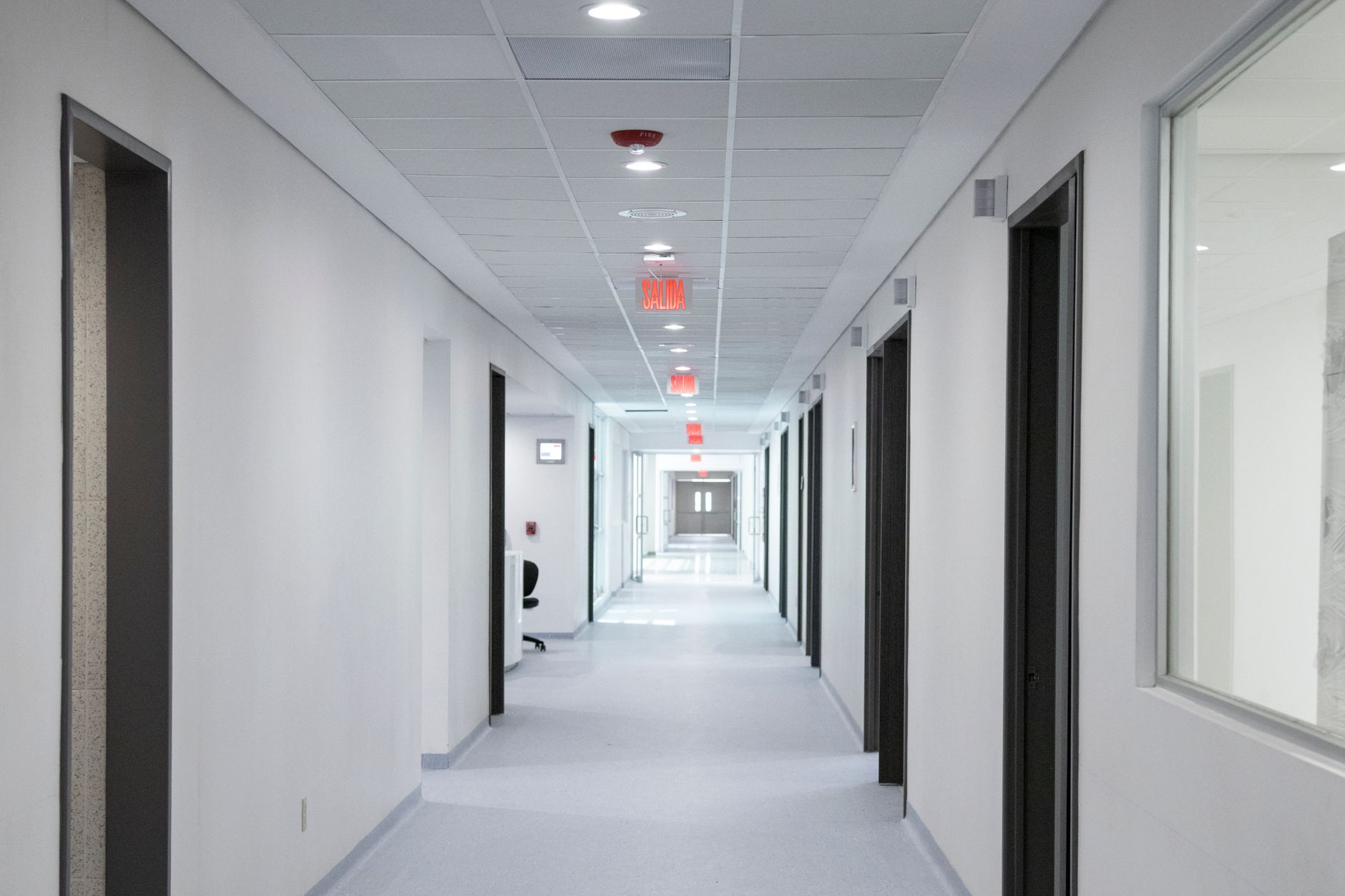 Bright, inviting hallway of a modern clinic in Istanbul, showcasing rooms and emergency exit signs.