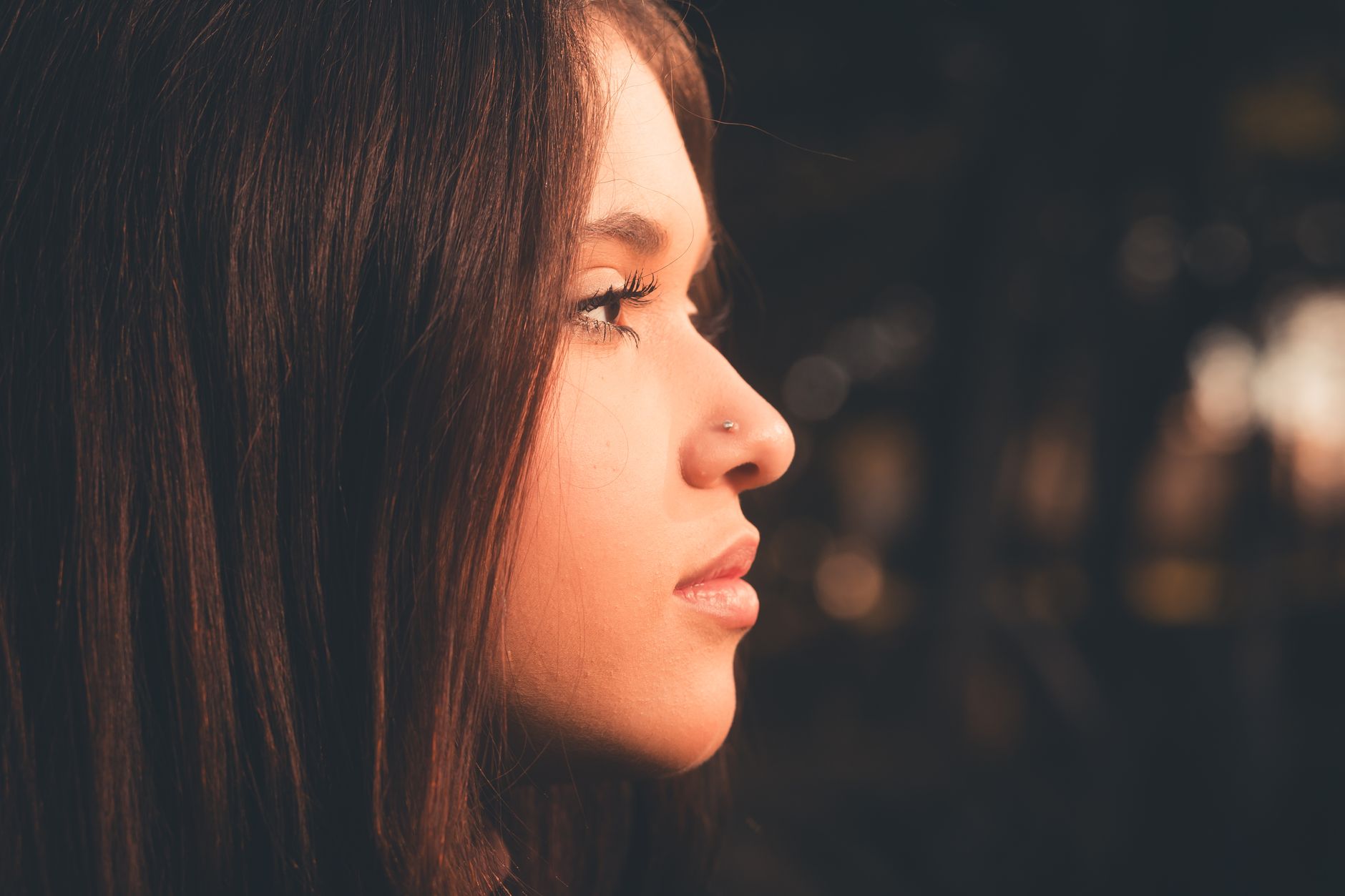 Profile view of a young woman showcasing natural rhinoplasty results with subtle facial balance.