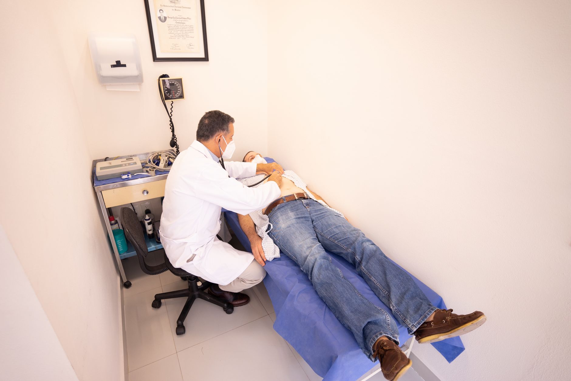 A doctor examines a patient in a recovery room in a medical facility.