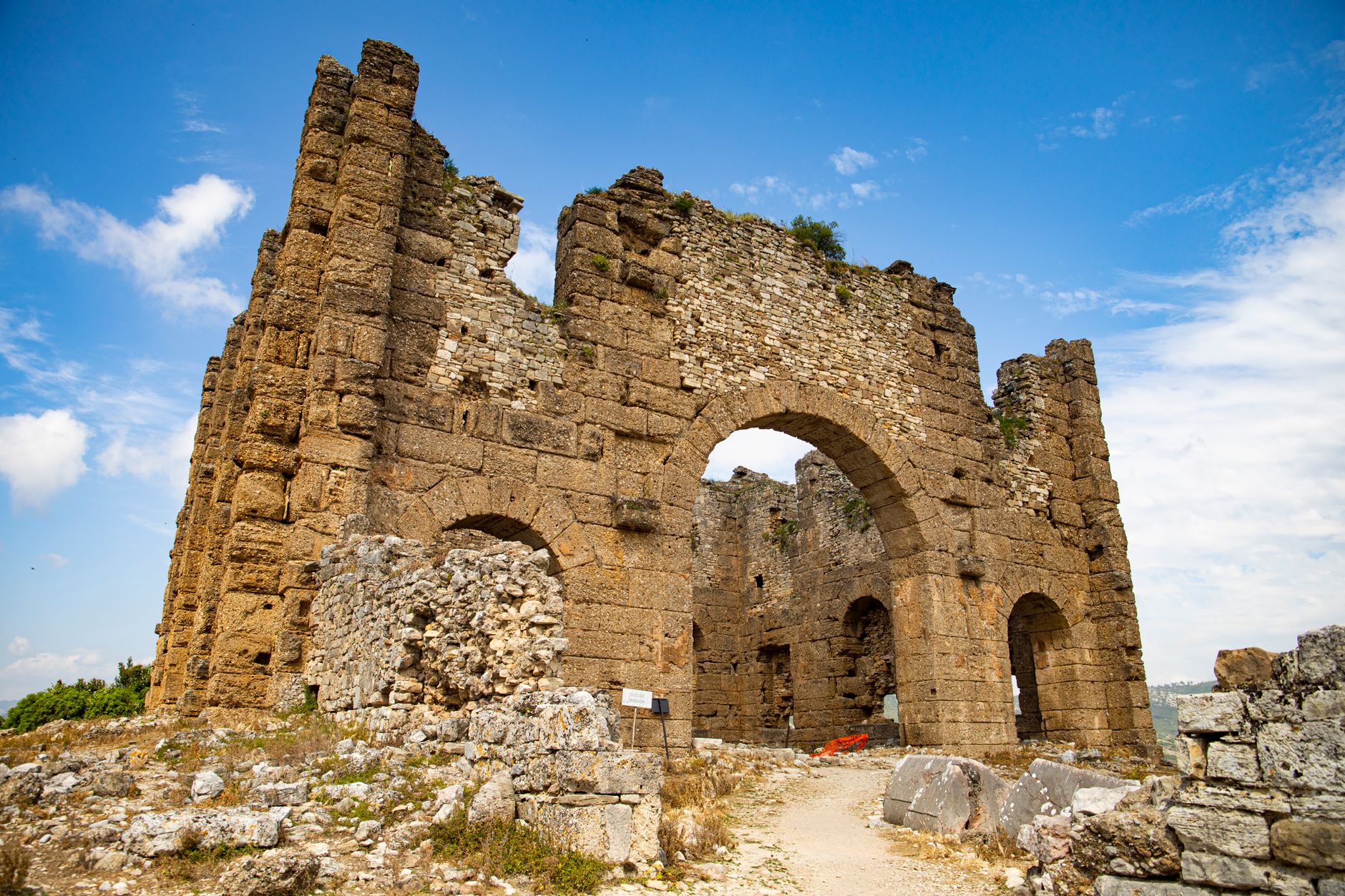 View of ancient stone ruins in Hatay, showcasing historical architecture against a blue sky.