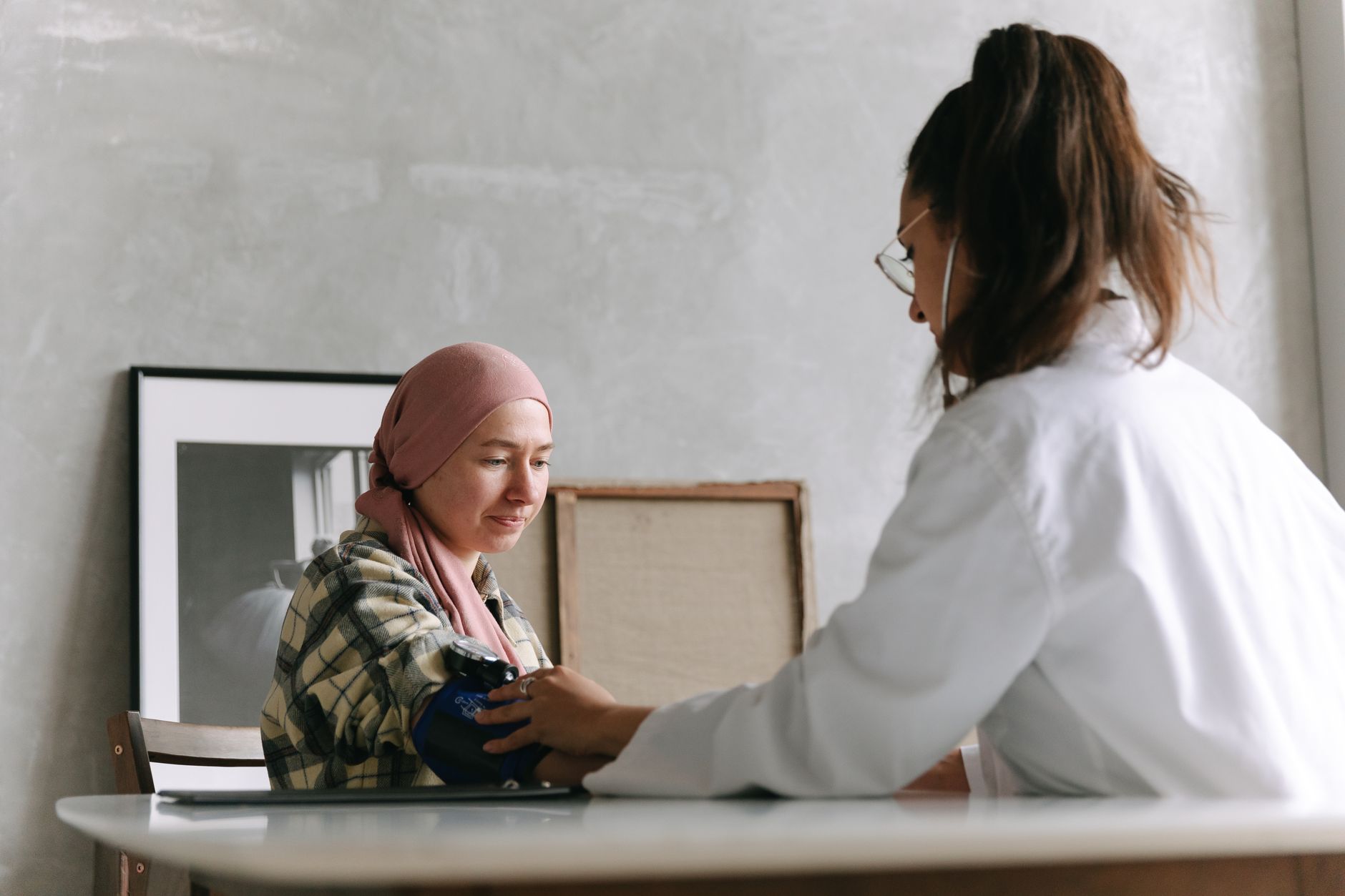 A female doctor checks a patient's blood pressure in a warm, inviting setting.