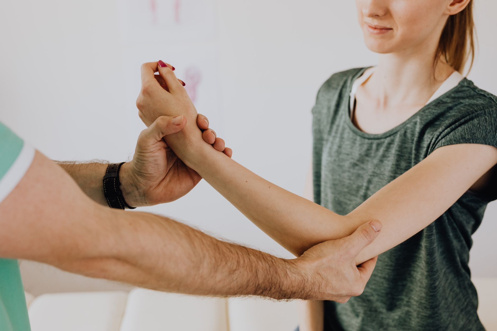 A physiotherapist guides a patient in arm exercises for rehabilitation.