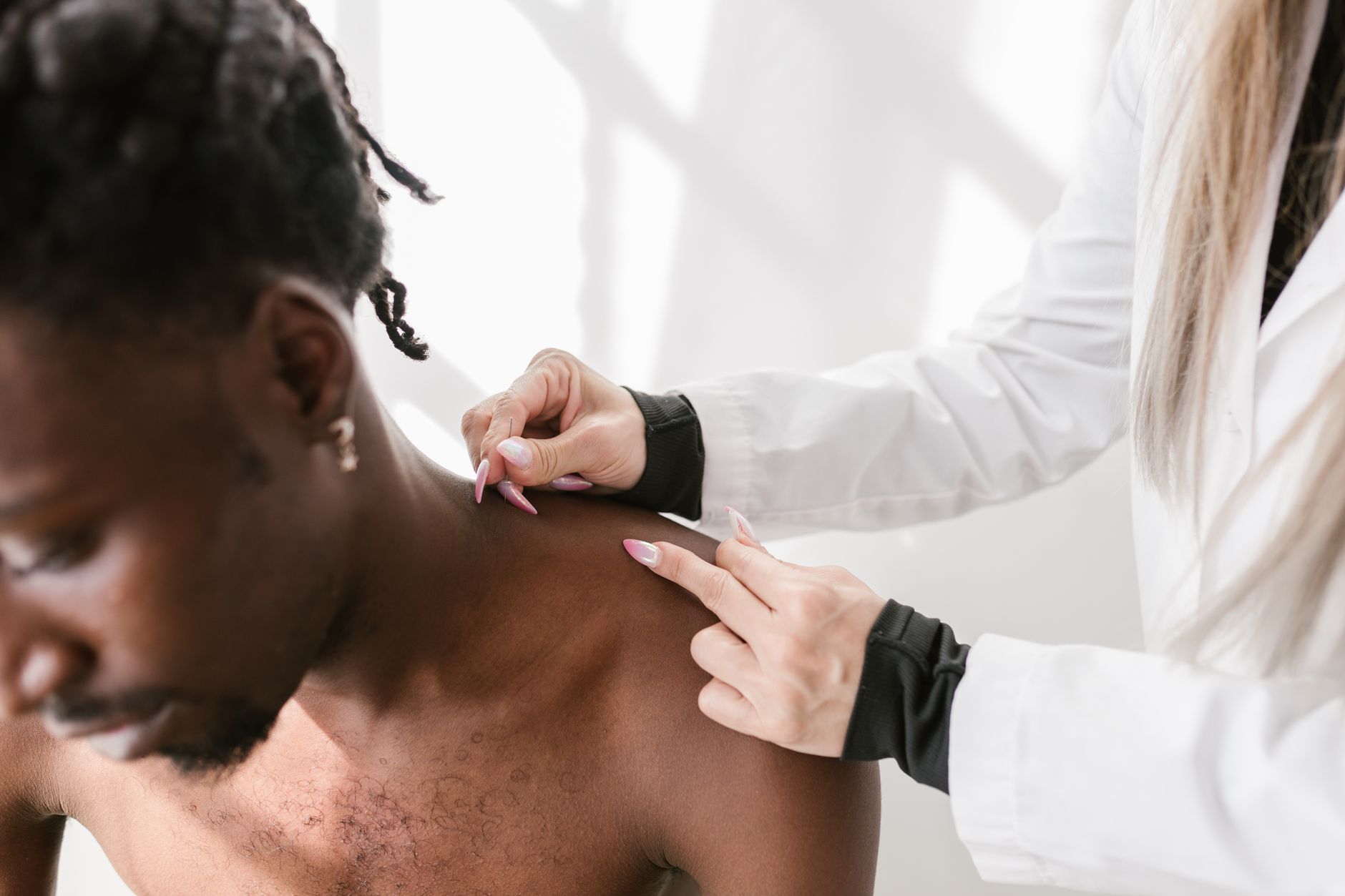 A healthcare professional examines a patient's shoulder during an arthroscopy procedure.
