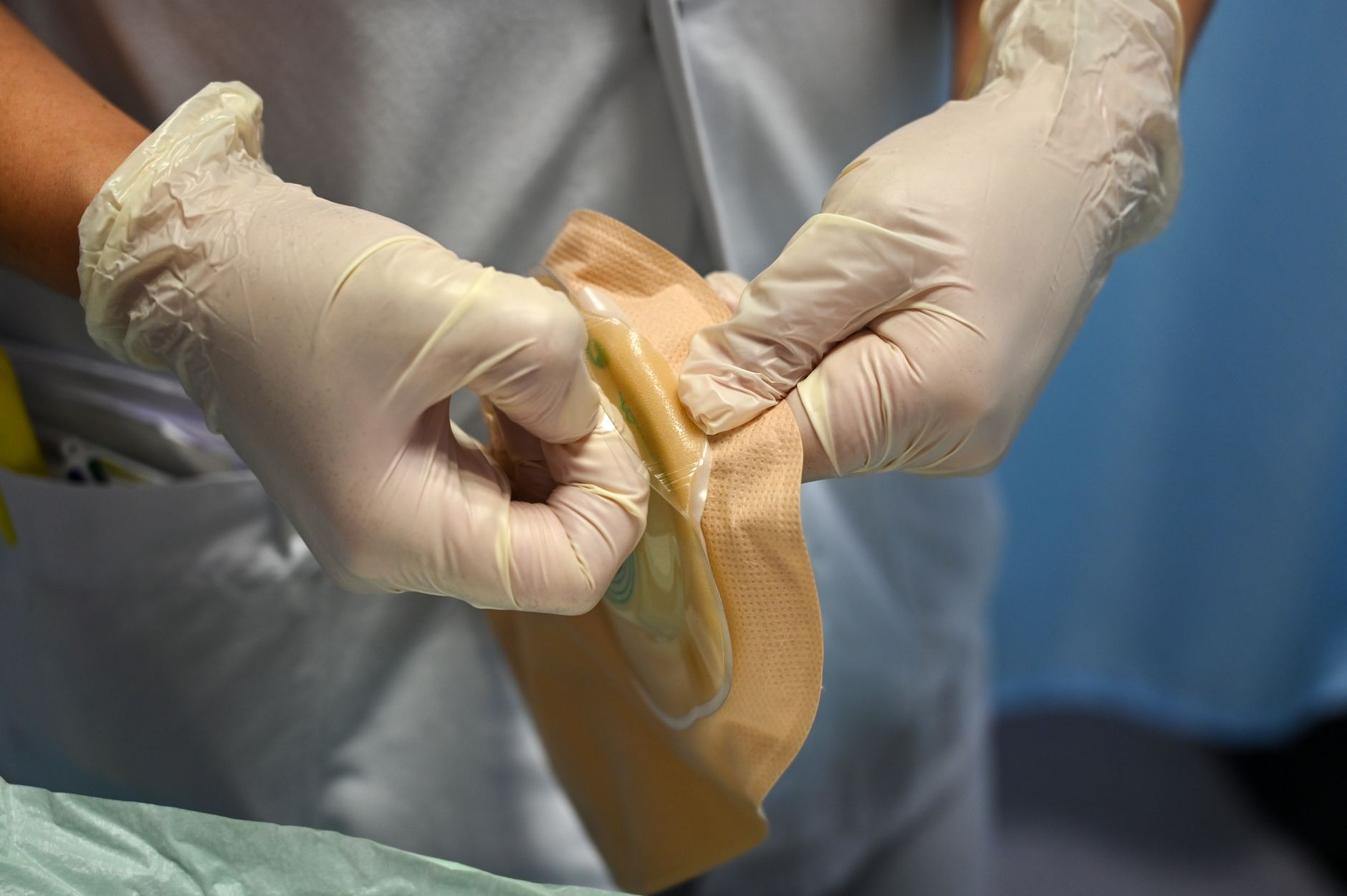 A therapist uses gloves to prepare materials for a patient's dysphagia rehabilitation session.