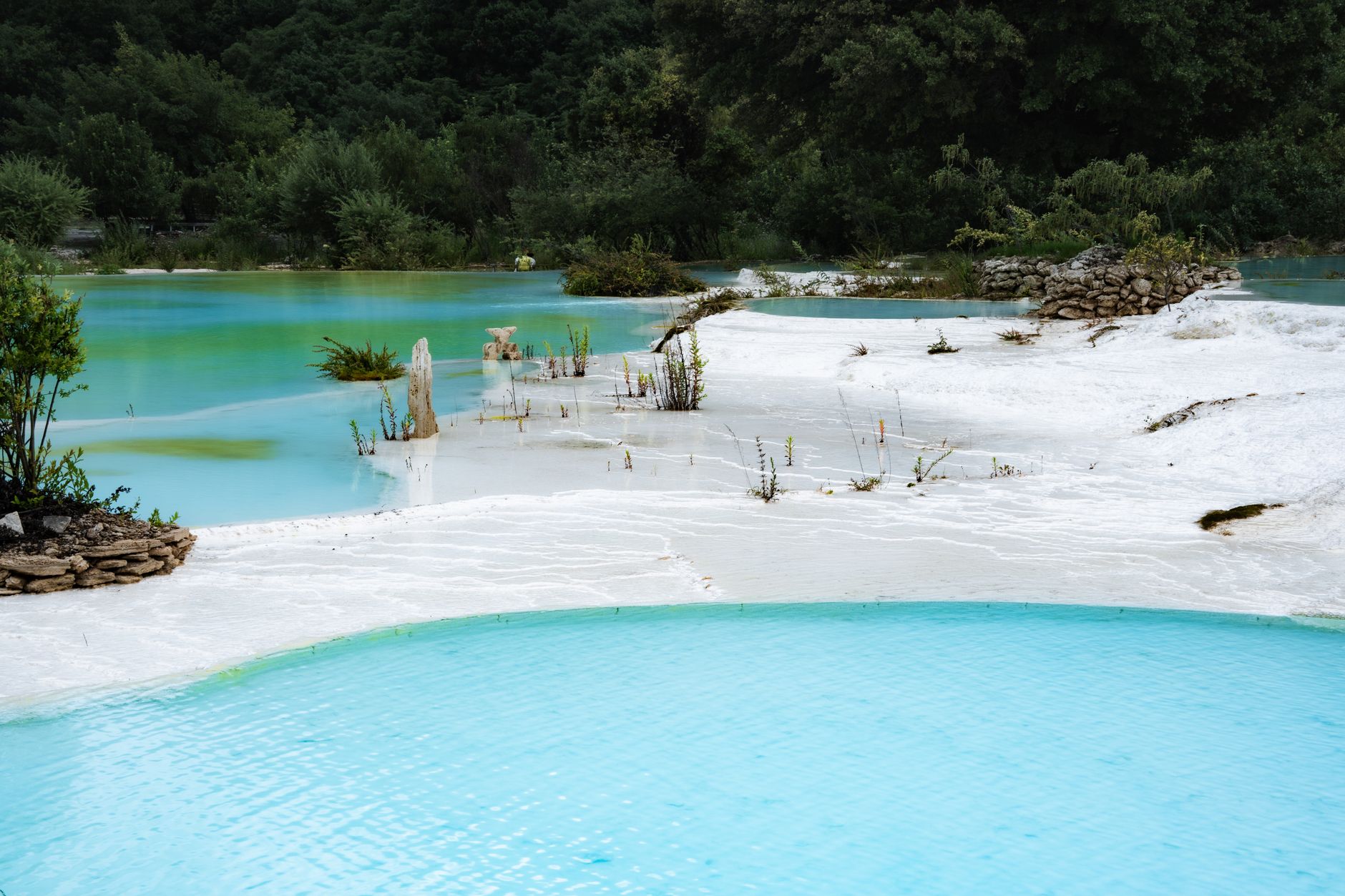 A tranquil thermal spring in Bursa, featuring turquoise water and white mineral deposits, ideal for recovery.