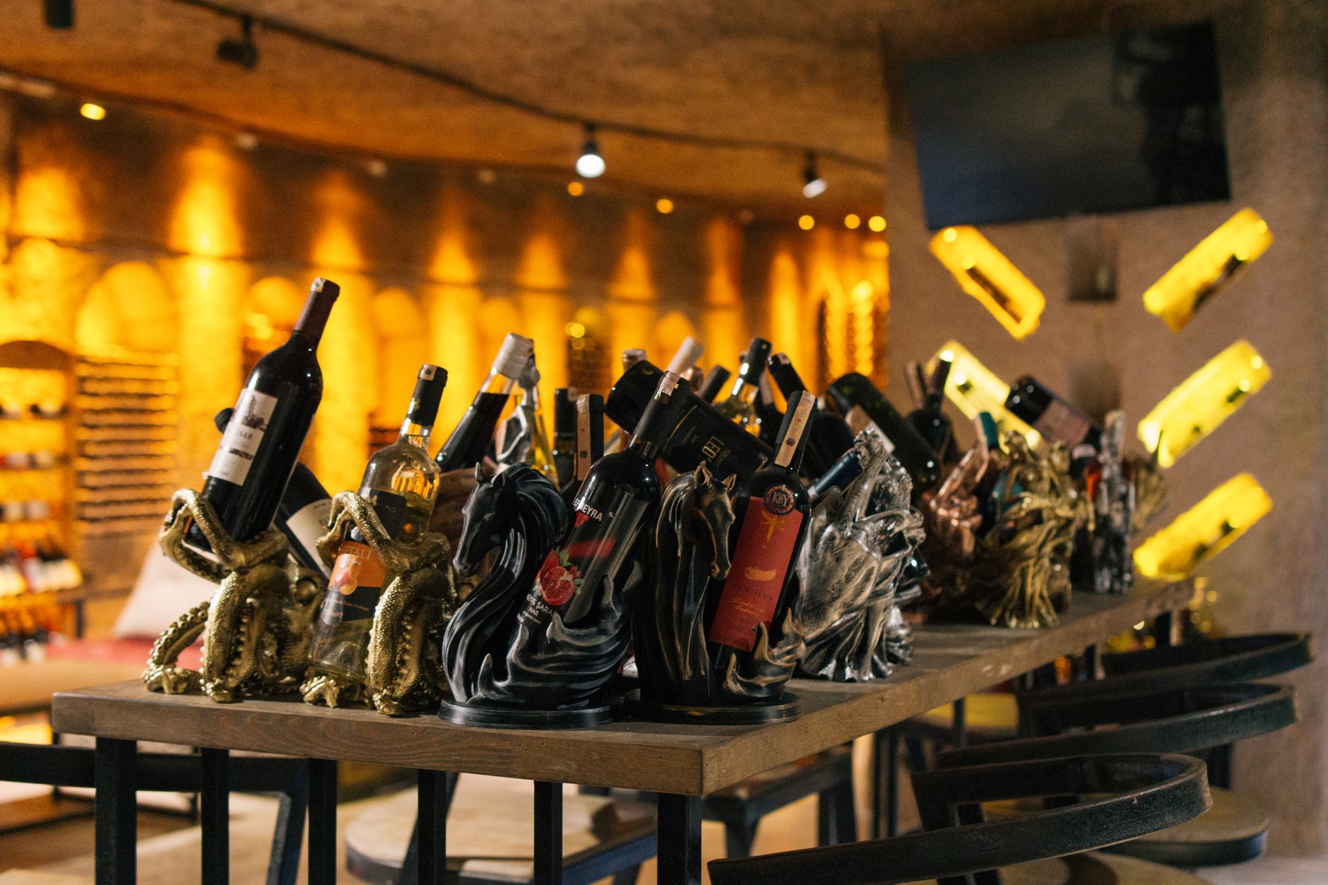 Contemporary wine display featuring artistic horse and octopus bottle holders.