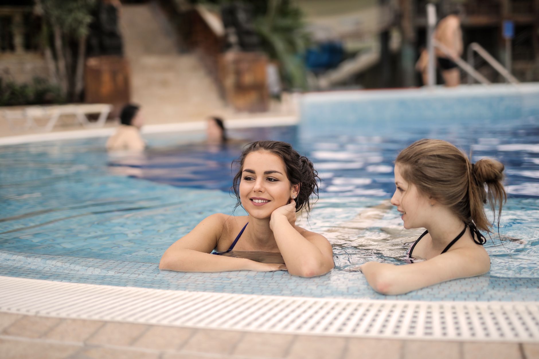 Two women relaxed in a thermal pool at a wellness resort, enjoying gentle hydrotherapy.