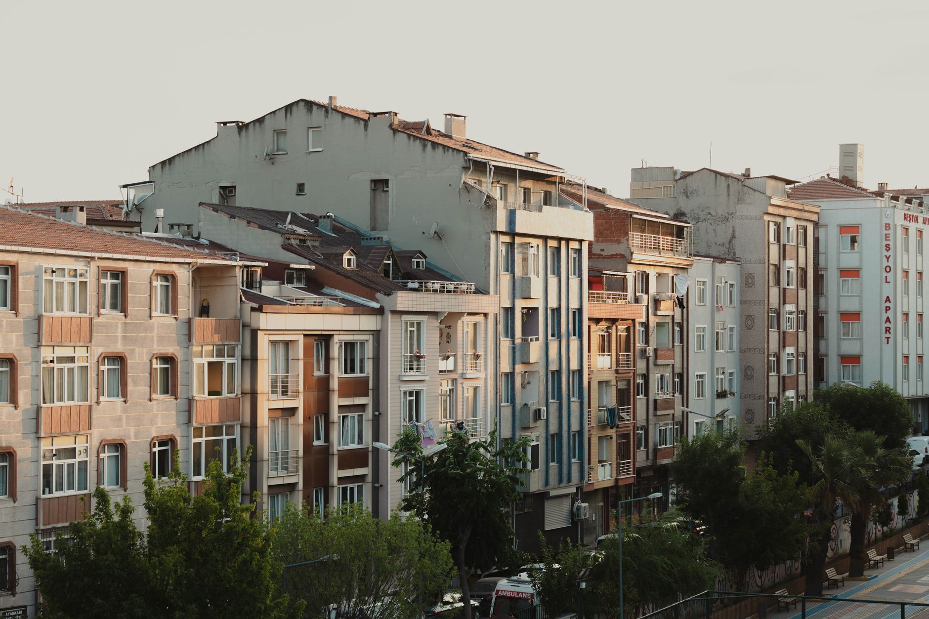 A view of cozy serviced apartments in Istanbul, showcasing building architecture and greenery.