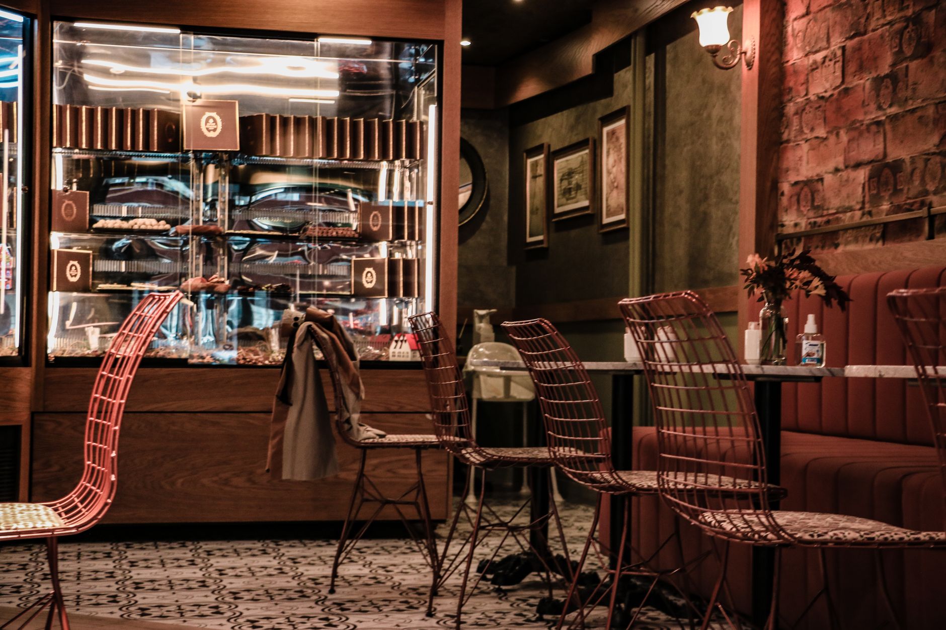 Stylish café setting featuring wire chairs and dessert display in Türkiye.