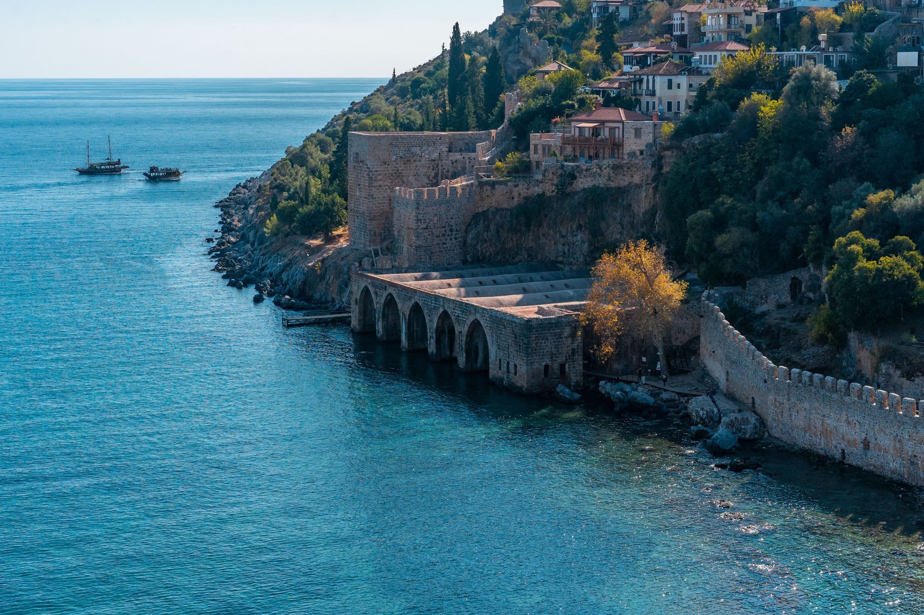 A peaceful coastal scene in Antalya featuring historic architecture and calm waters.