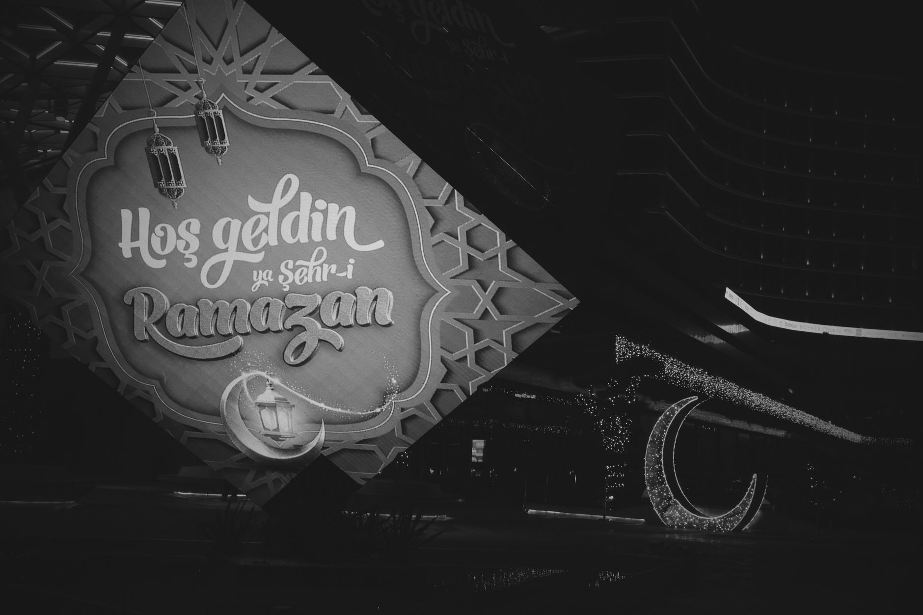 Black and white image of Ramadan decorations in Istanbul, featuring festive lights and a welcoming sign.