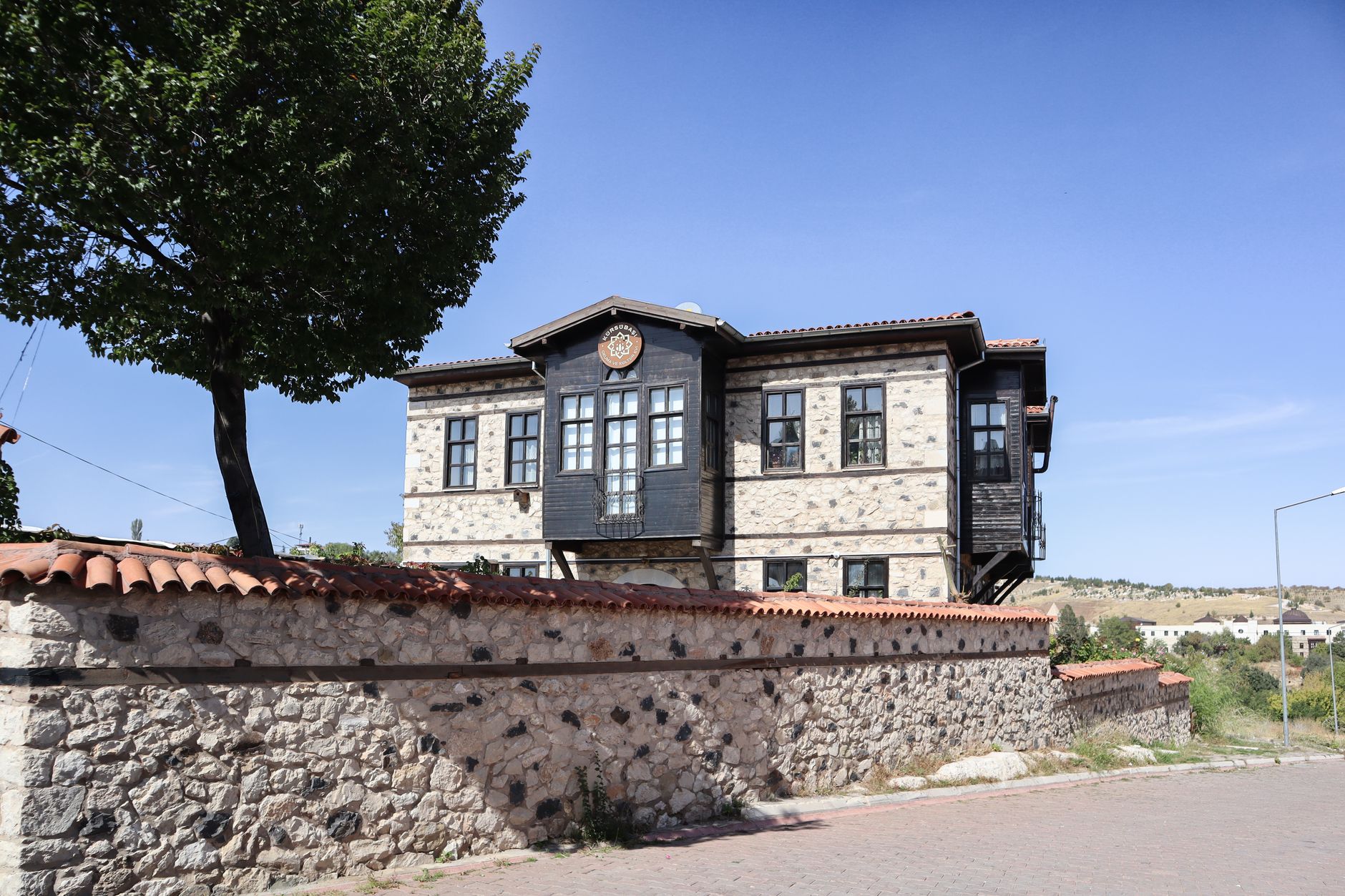 A historic stone and wooden building in Kahramanmaraş, showcasing traditional architecture against a blue sky.