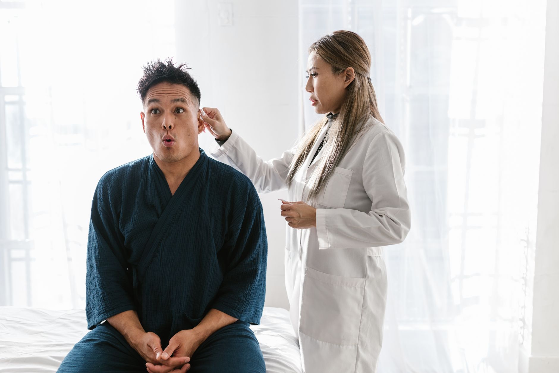 A neurosurgeon examines MRI scans with a patient in a bright consultation room.