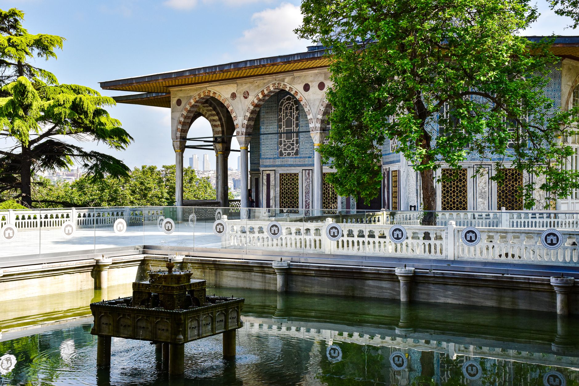 افرادی که در حیاطی آرام و احاطه‌شده با سرسبزی چای می‌نوشند.
