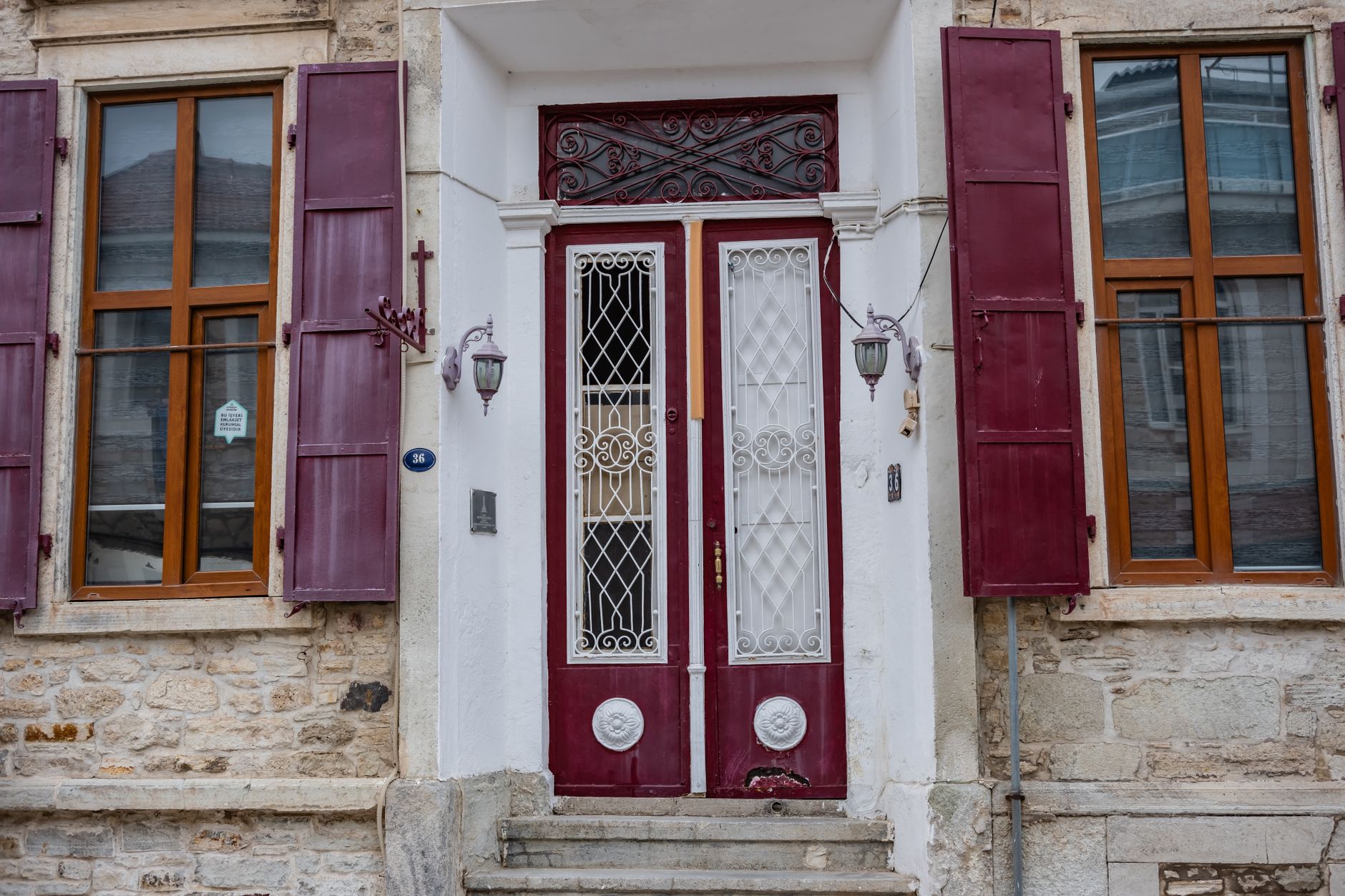 Close-up of an ornate Turkish door featuring painted details and a brass knocker.