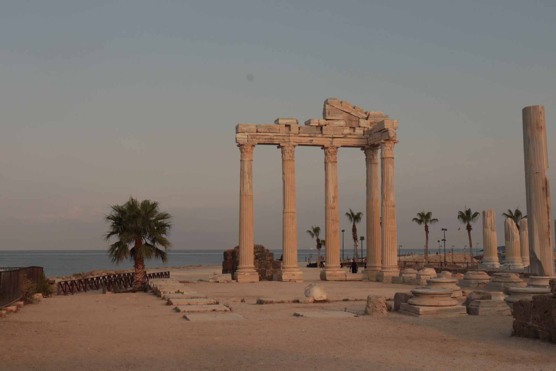 Ruins of the Temple of Apollo in Side, featuring columns with a sea backdrop and few tourists.