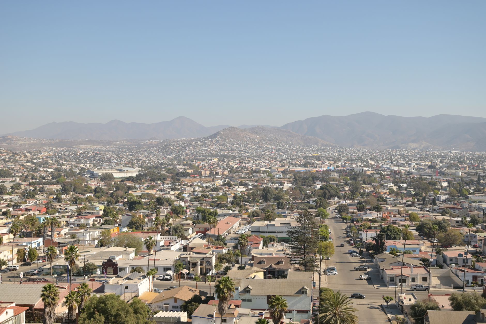 Aerial view of Tijuana showcasing urban landscape and mountains beyond.