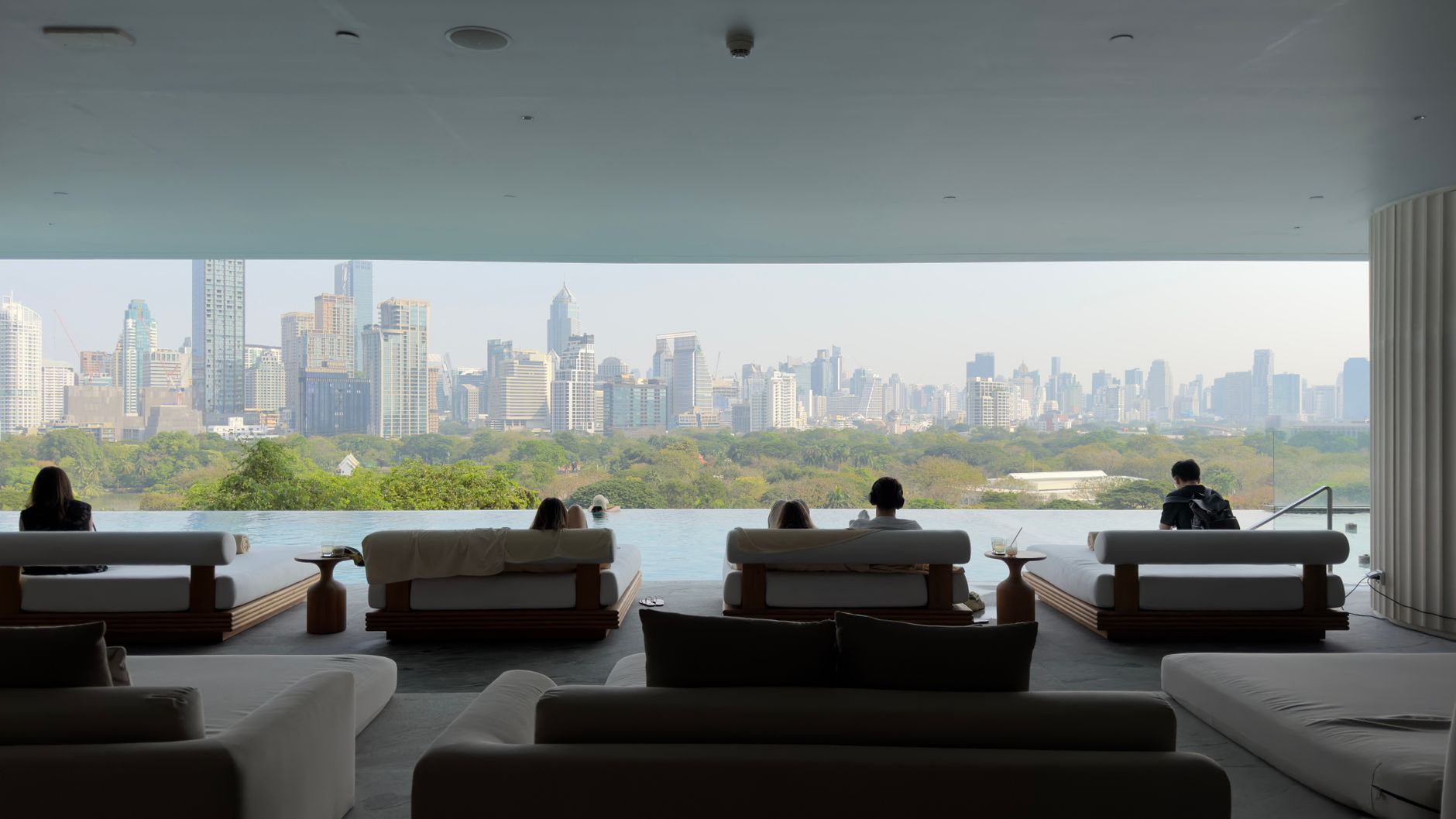 Elegant lobby in Bangkok featuring modern furniture and a city view.