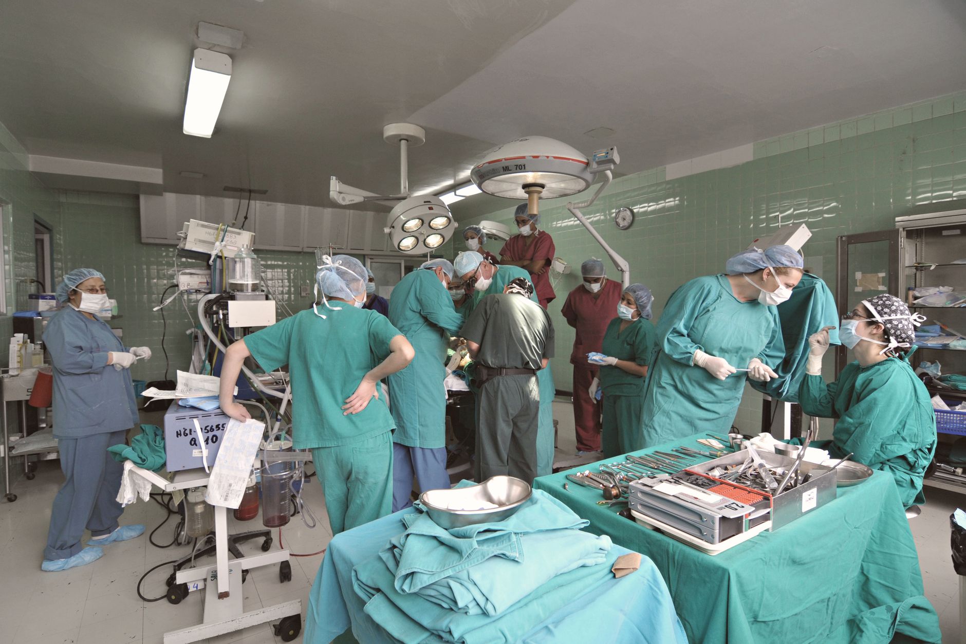 A busy surgical team operates in a modern Turkish hospital's operating room.